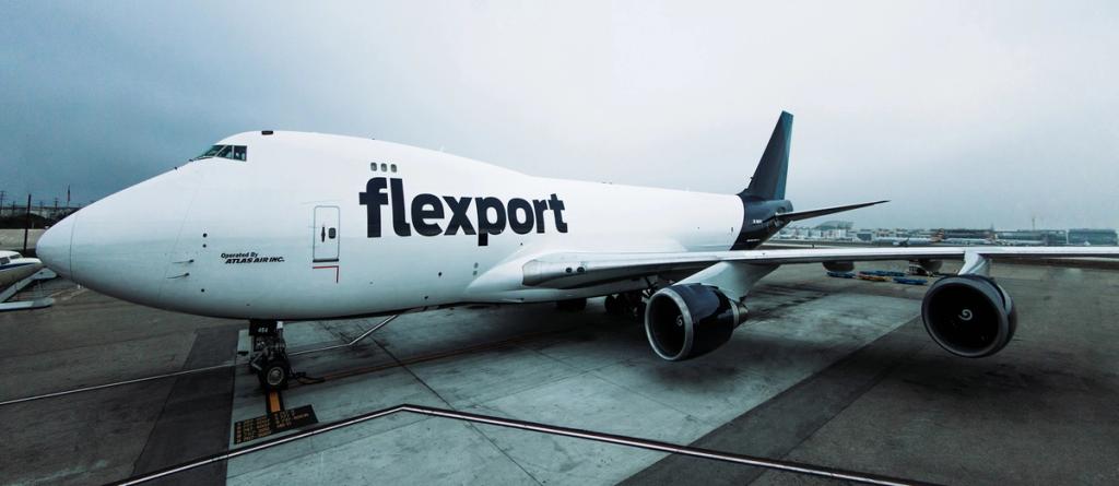 Flexport-branded Boeing 747 cargo freighter parked on an airport tarmac under an overcast sky