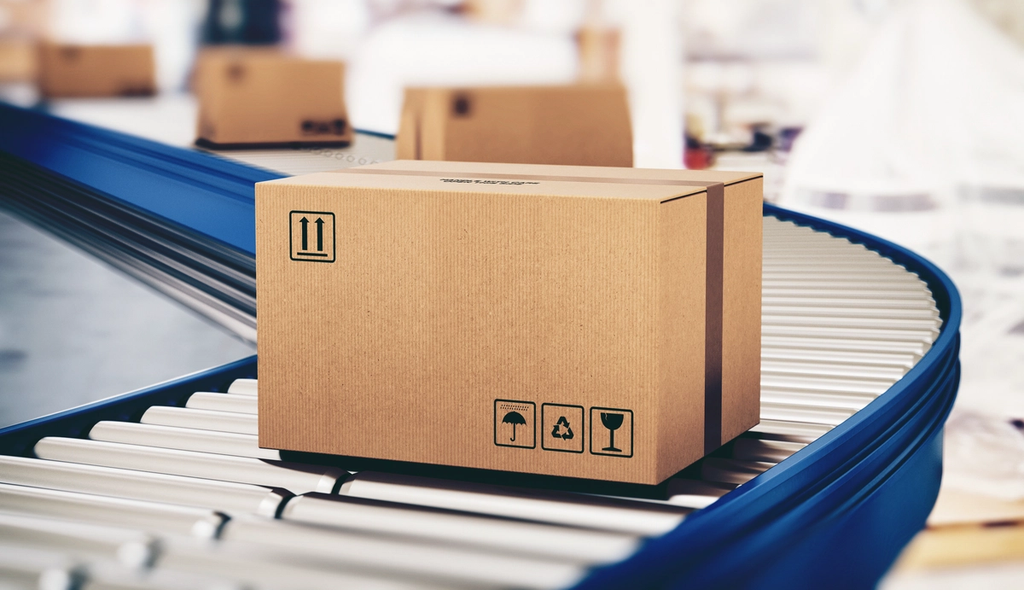 Cardboard shipping box moving along a blue roller conveyor in a warehouse