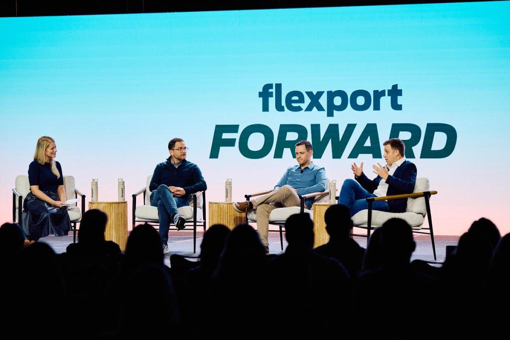 Four panelists seated on stage before a crowd under a large Flexport Forward backdrop
