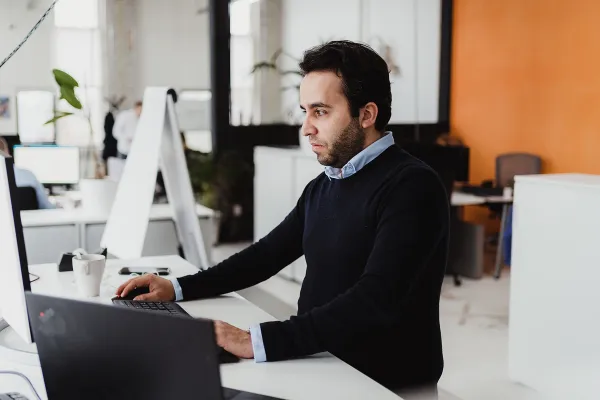 Business professional checking information on laptop, depicting analysis and focus.
