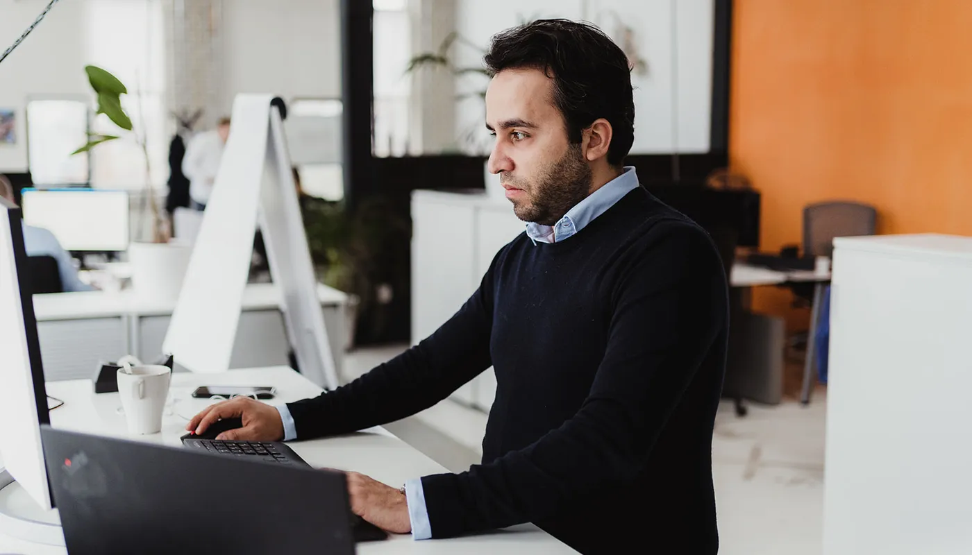 Business professional checking information on laptop, depicting analysis and focus.
