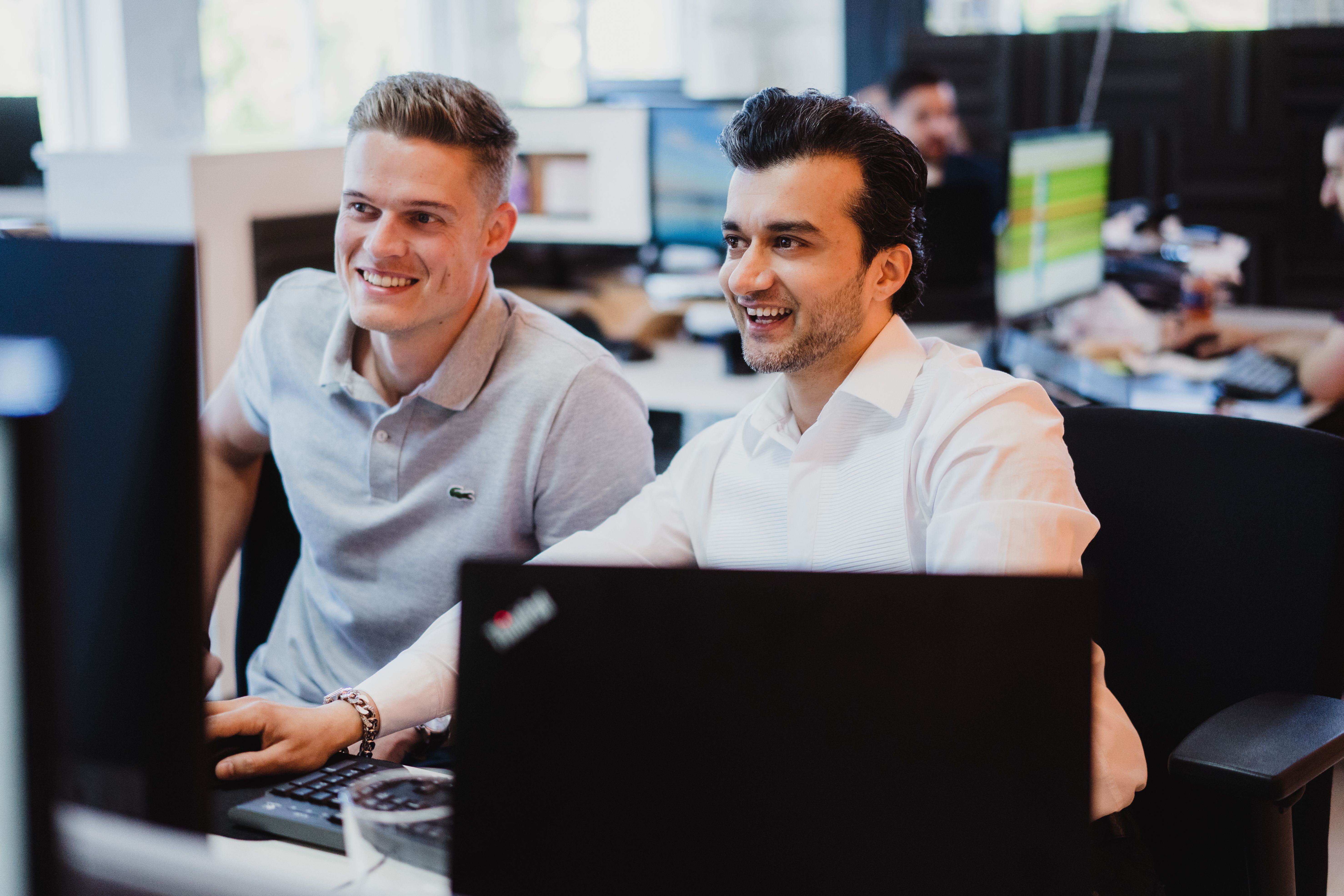A professional man in a white shirt focuses on his laptop in a modern studio office, representing the focused and transparent nature of modern EU hiring practices.