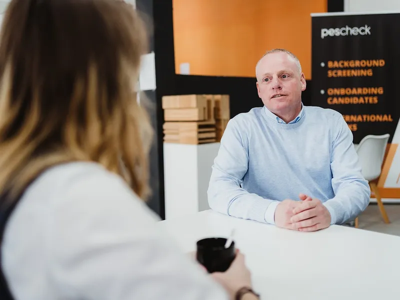 Recruiter and candidate in a background screening interview for European hiring, showing GDPR-compliant pre-employment checks and HR compliance.