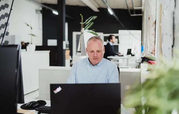 Vergrößerungsglas, das einen digitalen Lebenslauf scannt mit roten und grünen Markierungen, Symbol für rote Flaggen und verifizierte Informationen bei Pre-Employment-Screening.