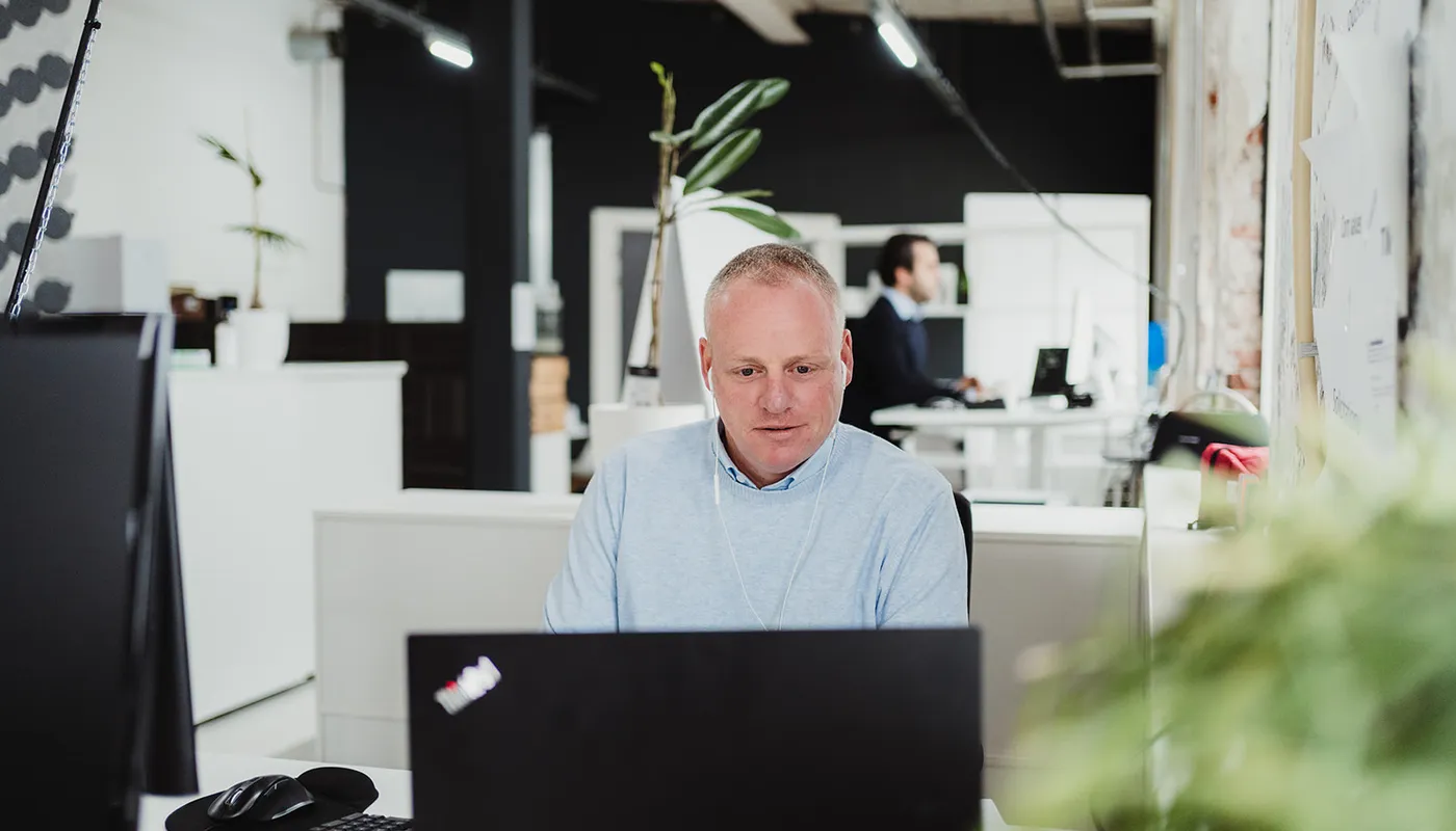 Vergrößerungsglas, das einen digitalen Lebenslauf scannt mit roten und grünen Markierungen, Symbol für rote Flaggen und verifizierte Informationen bei Pre-Employment-Screening.
