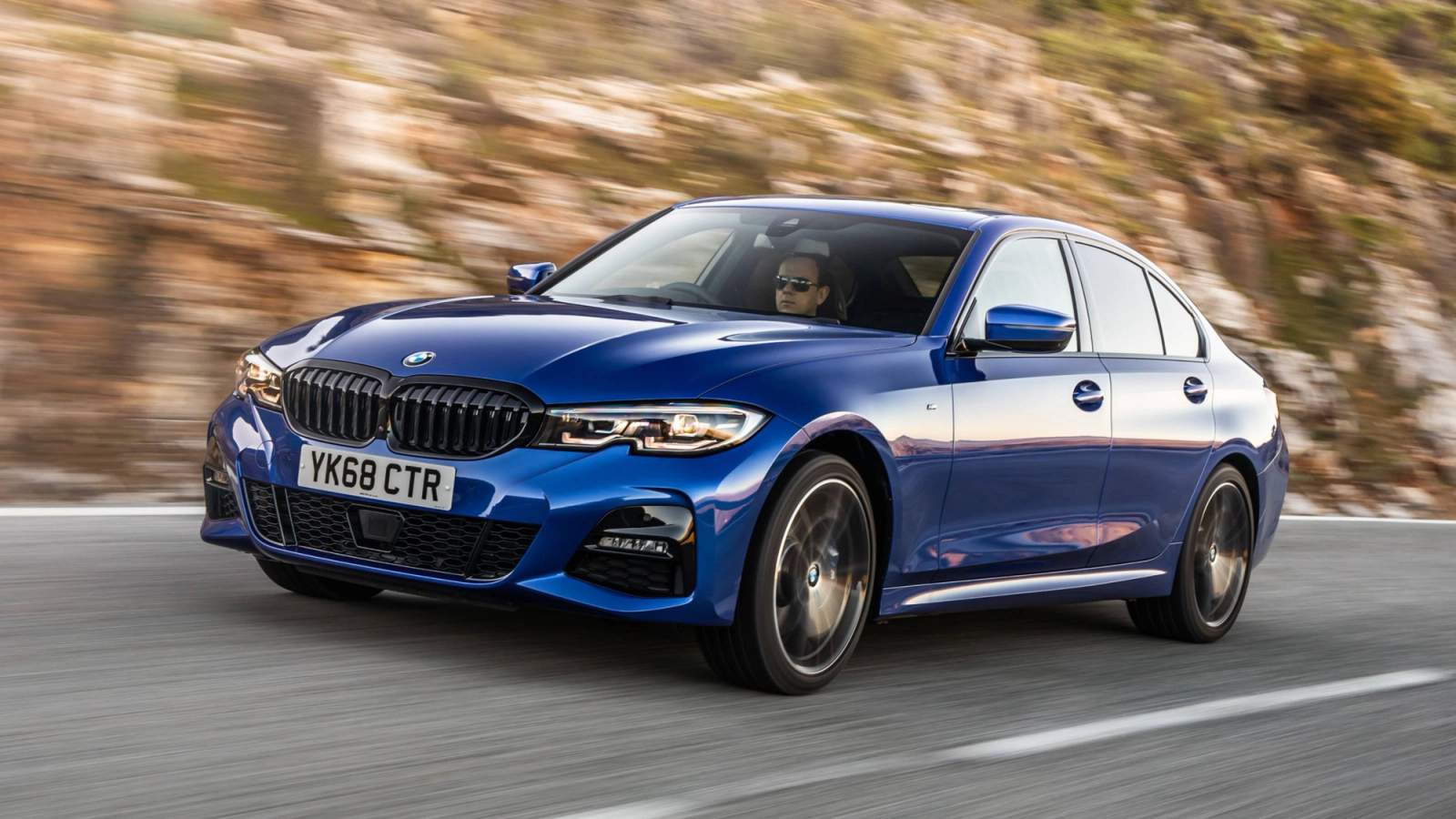 Blue BMW 3 Series saloon driving