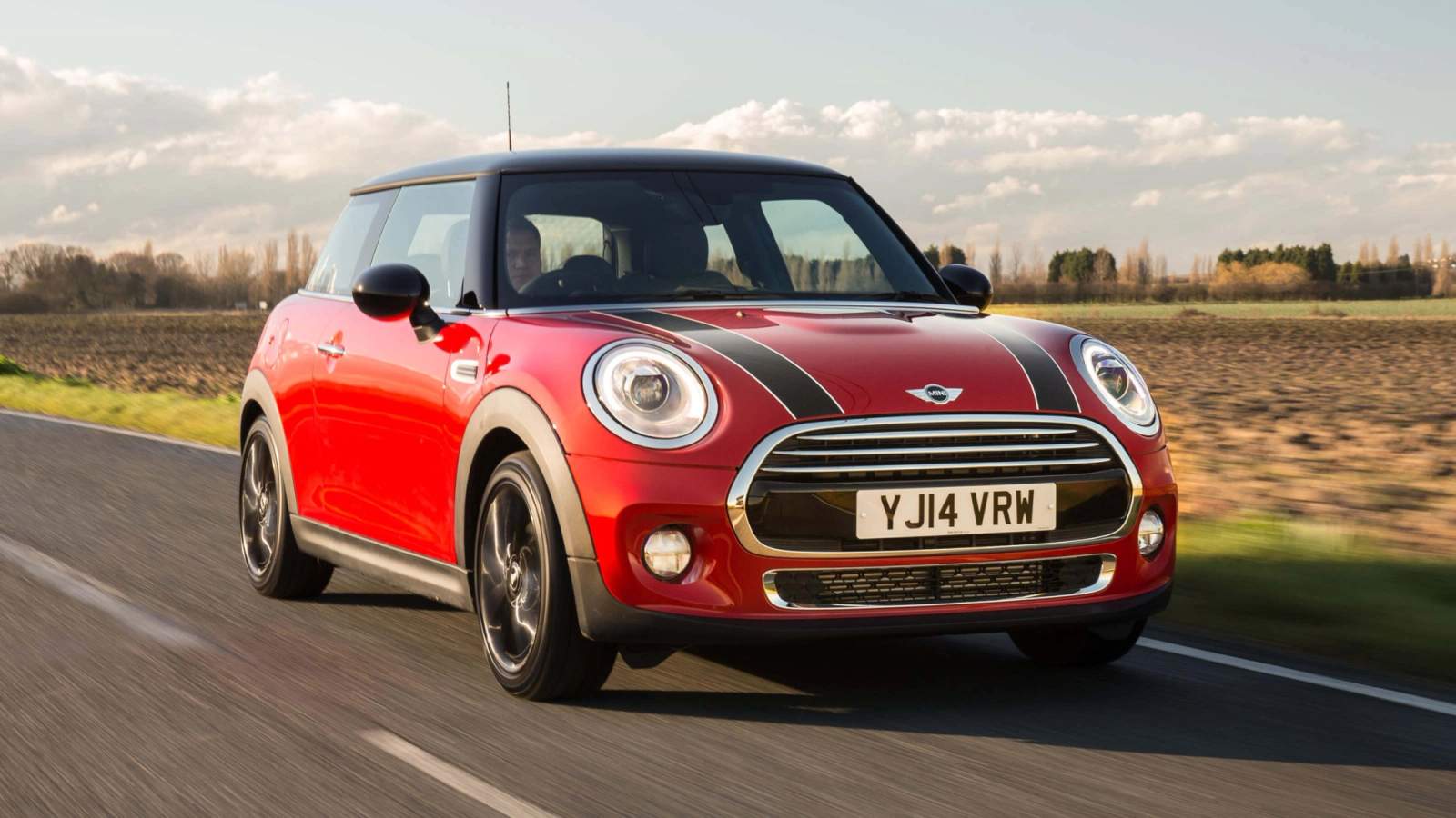 Red Mini Cooper driving along a road