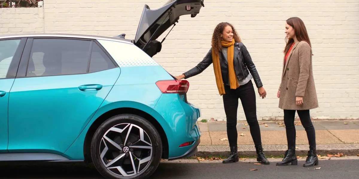 women near blue car