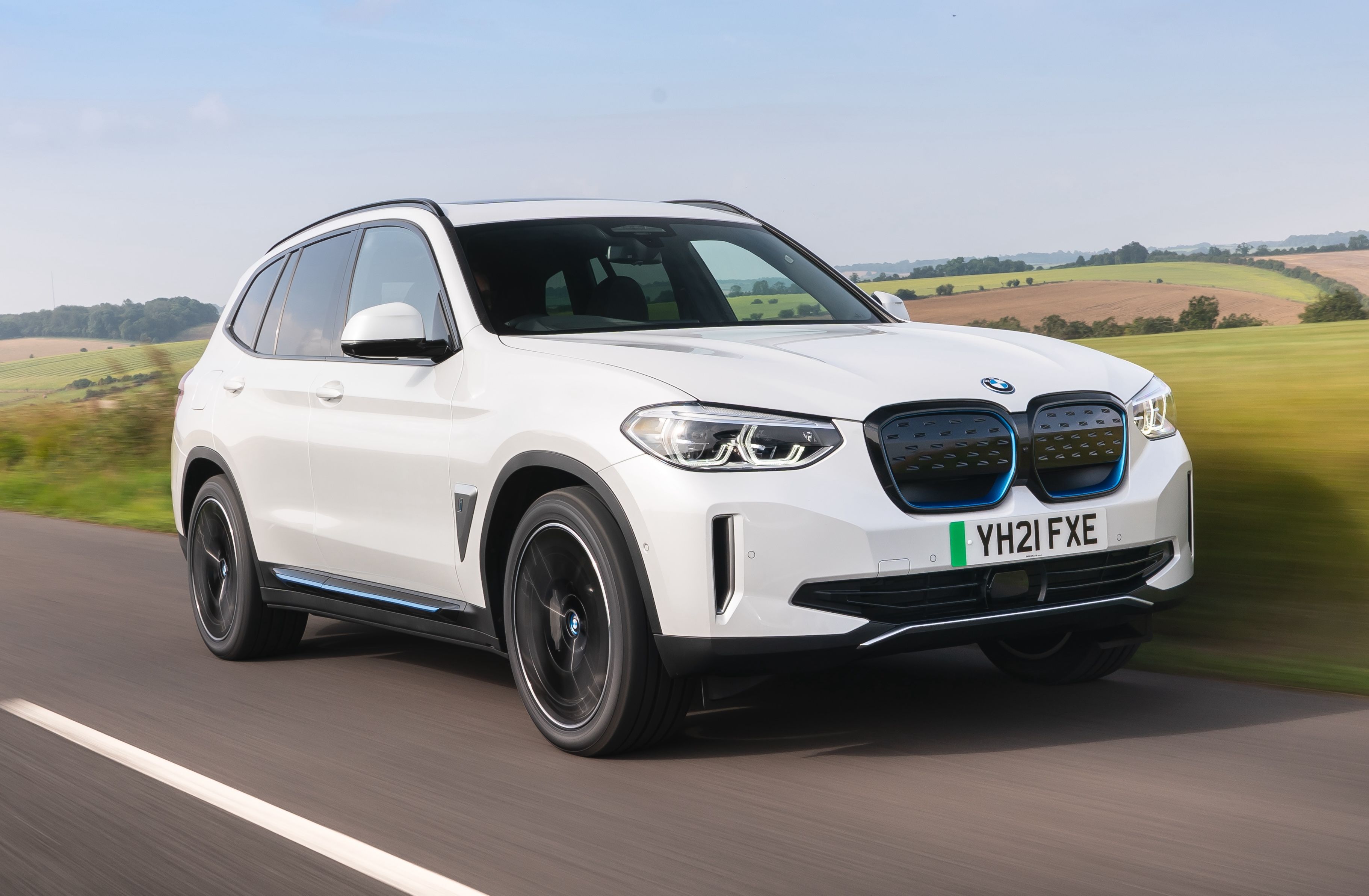 White BMW iX3 driving