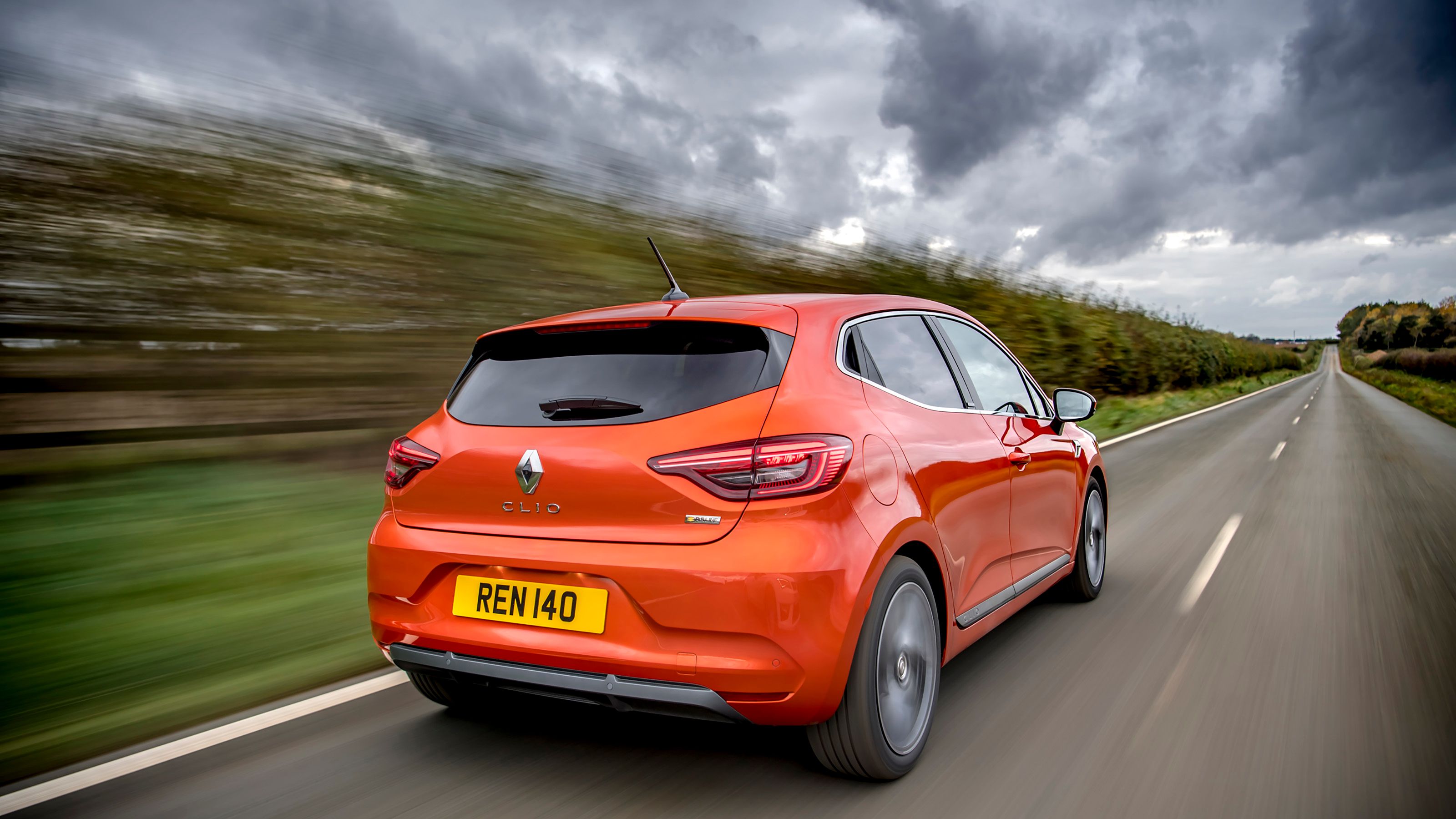 Orange Renault Clio rear driving