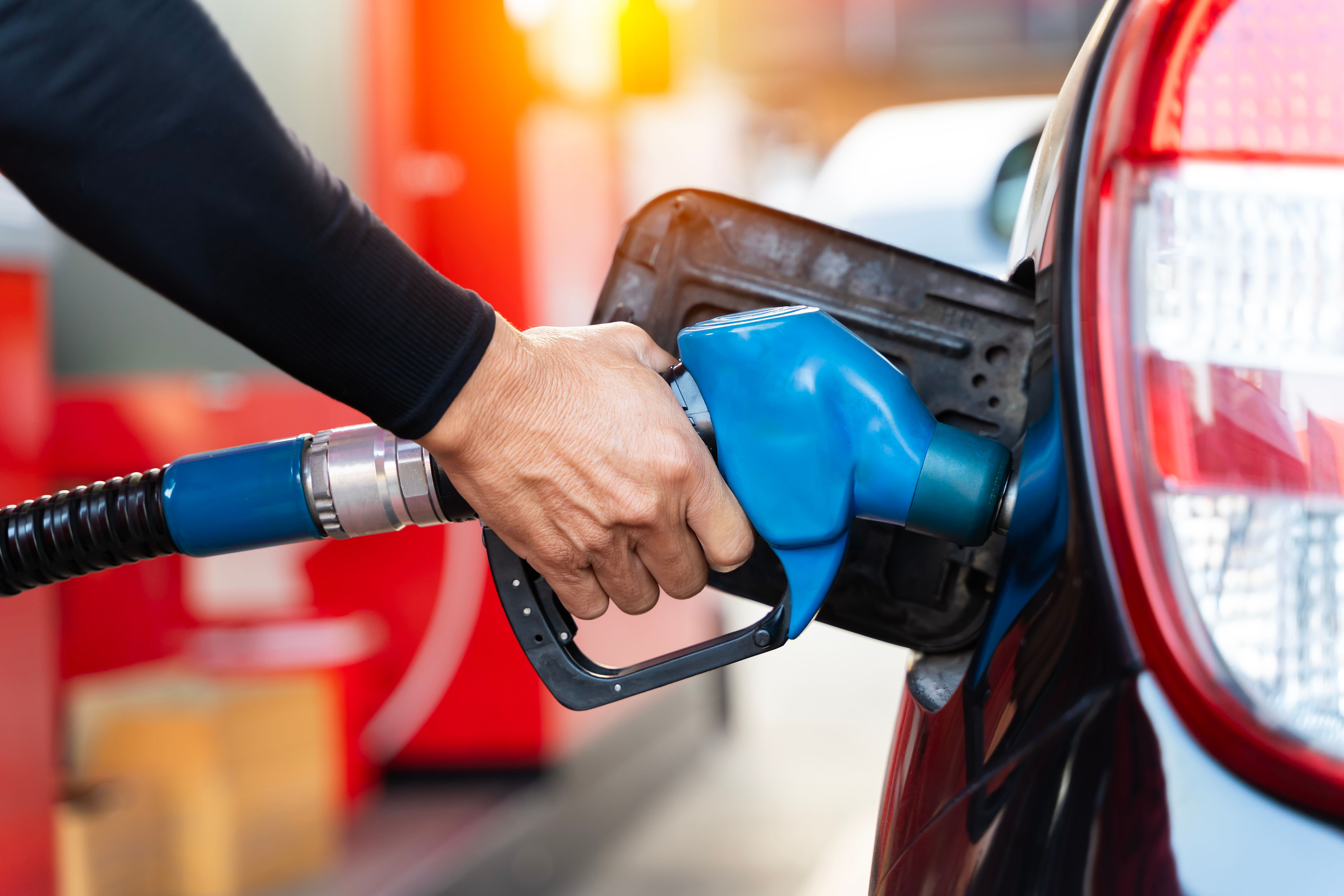 hand holding pump to refuel a car