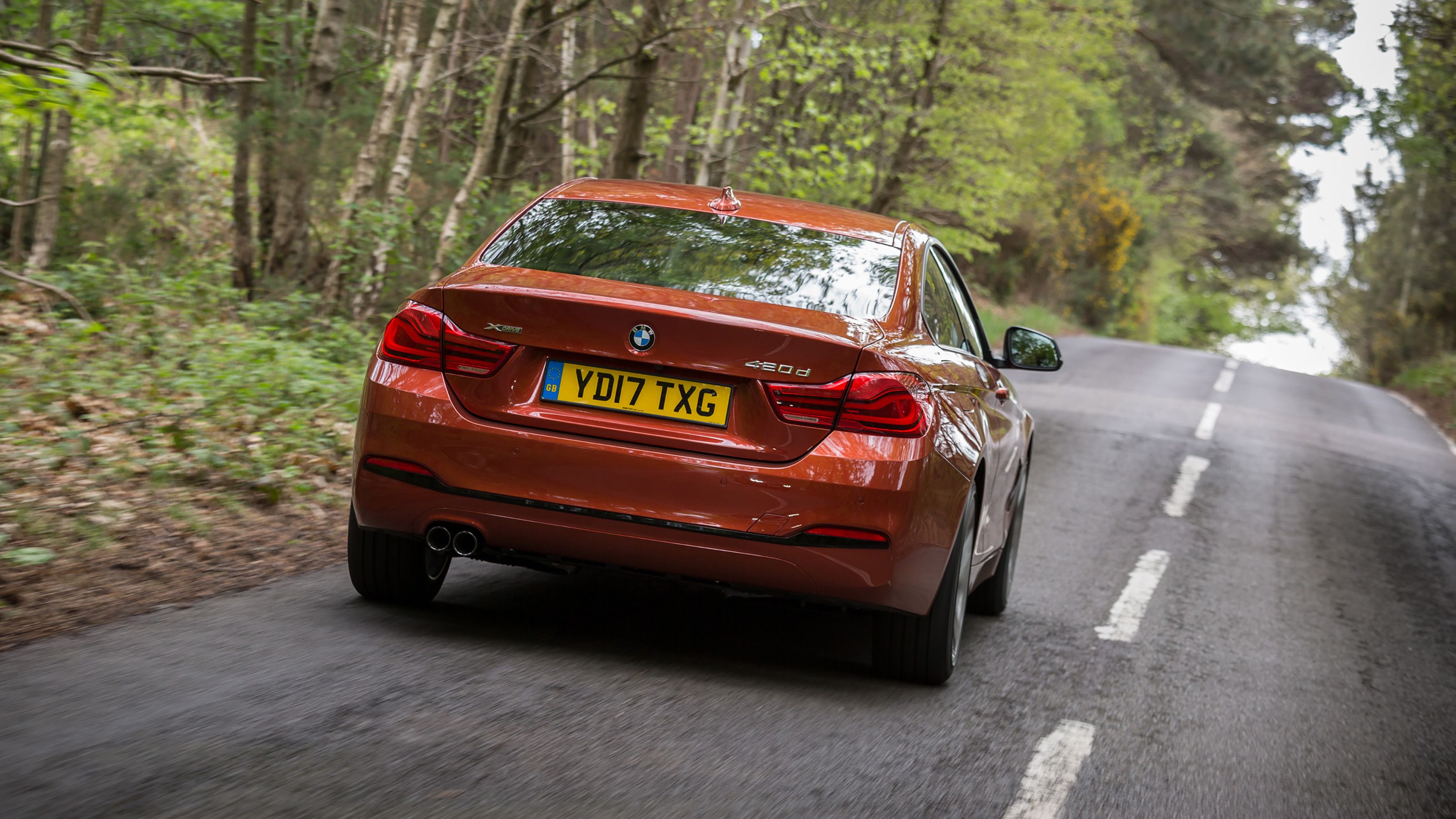 Orange BMW 4 Series rear driving