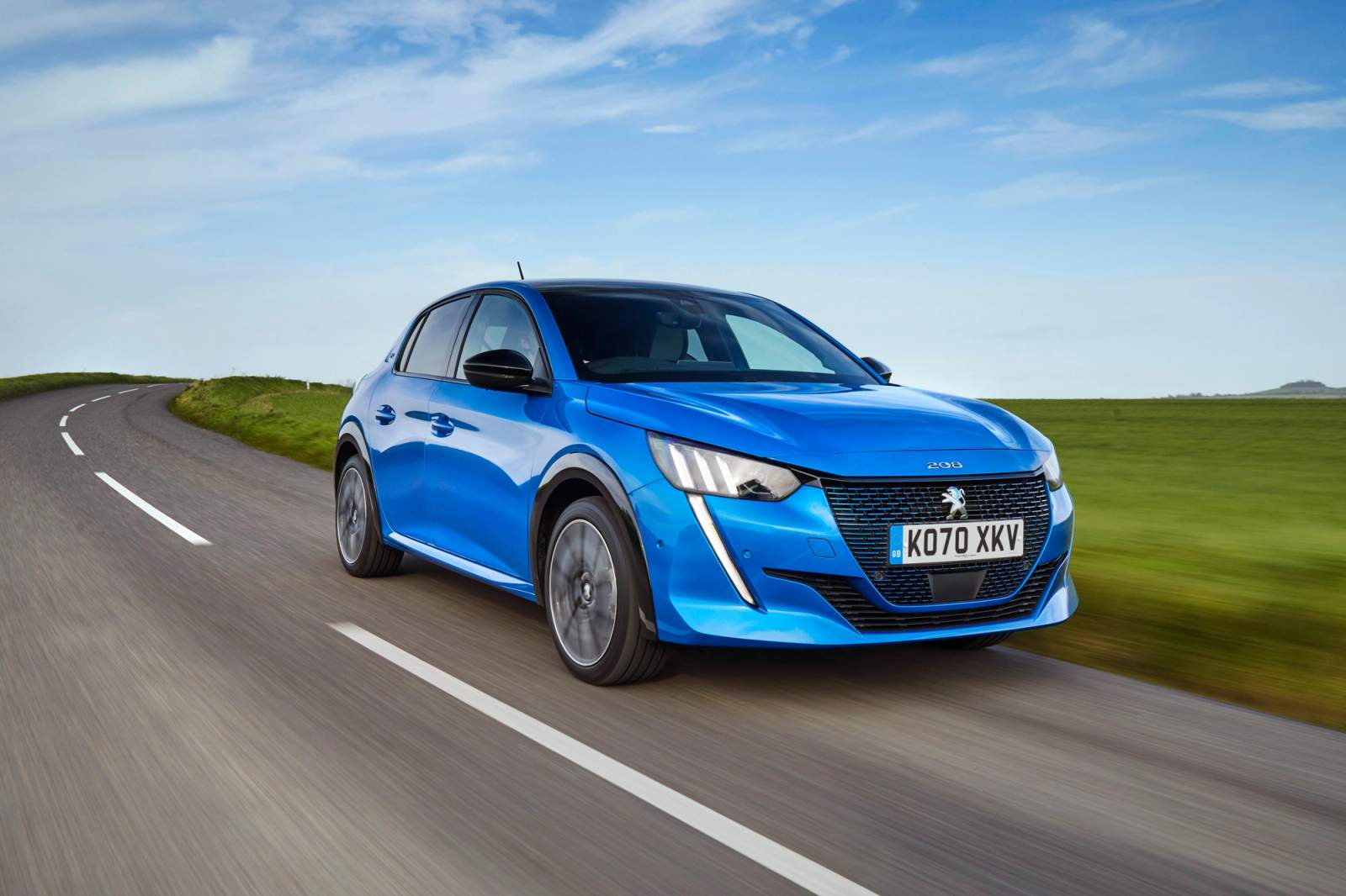 Blue Peugeot E-208 driving