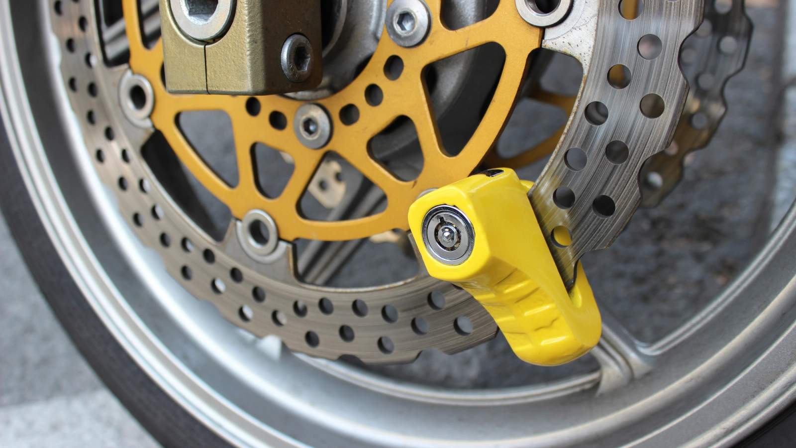 Yellow disc lock on motorbike wheel