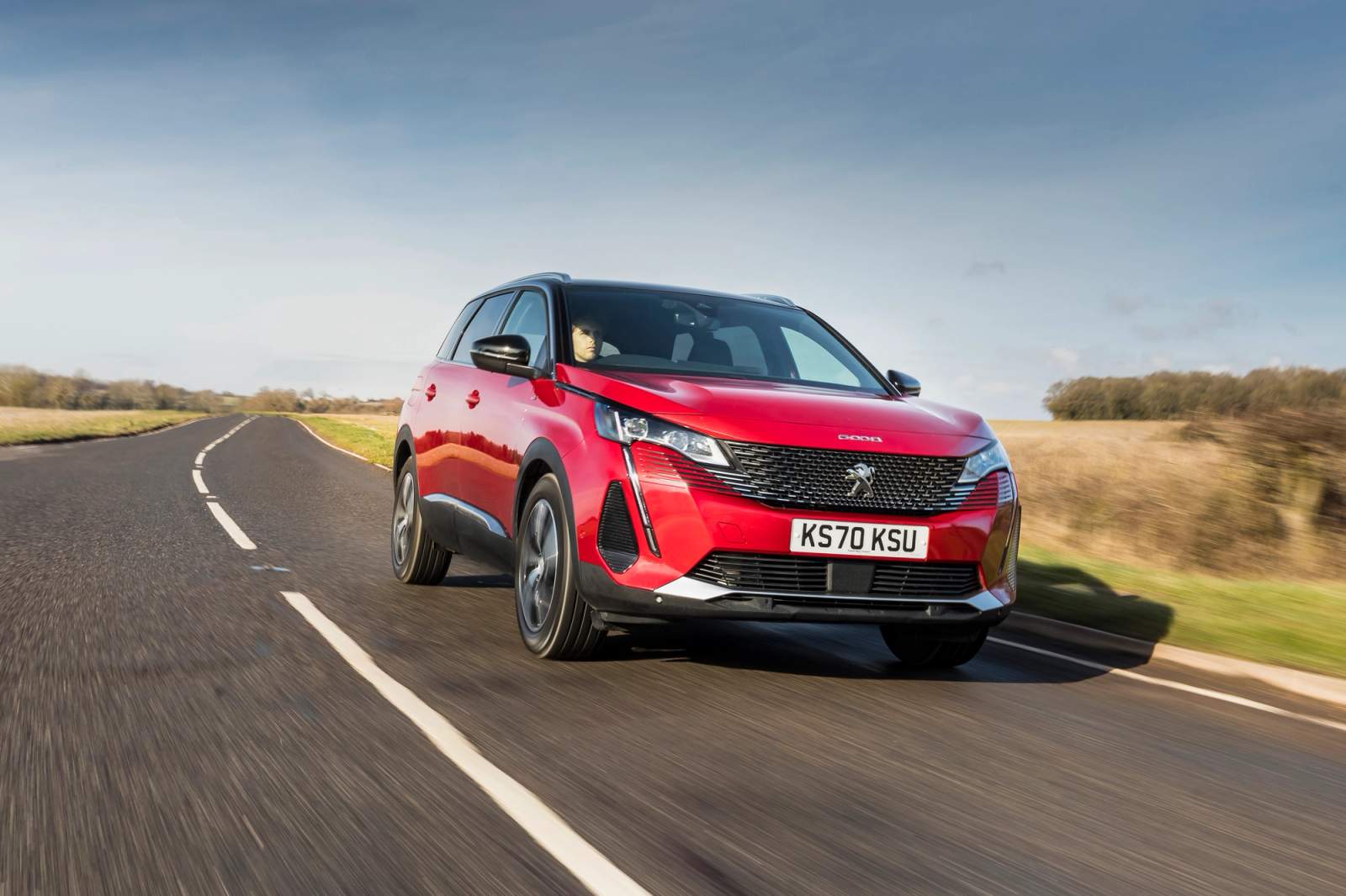 Red Peugeot 5008 driving