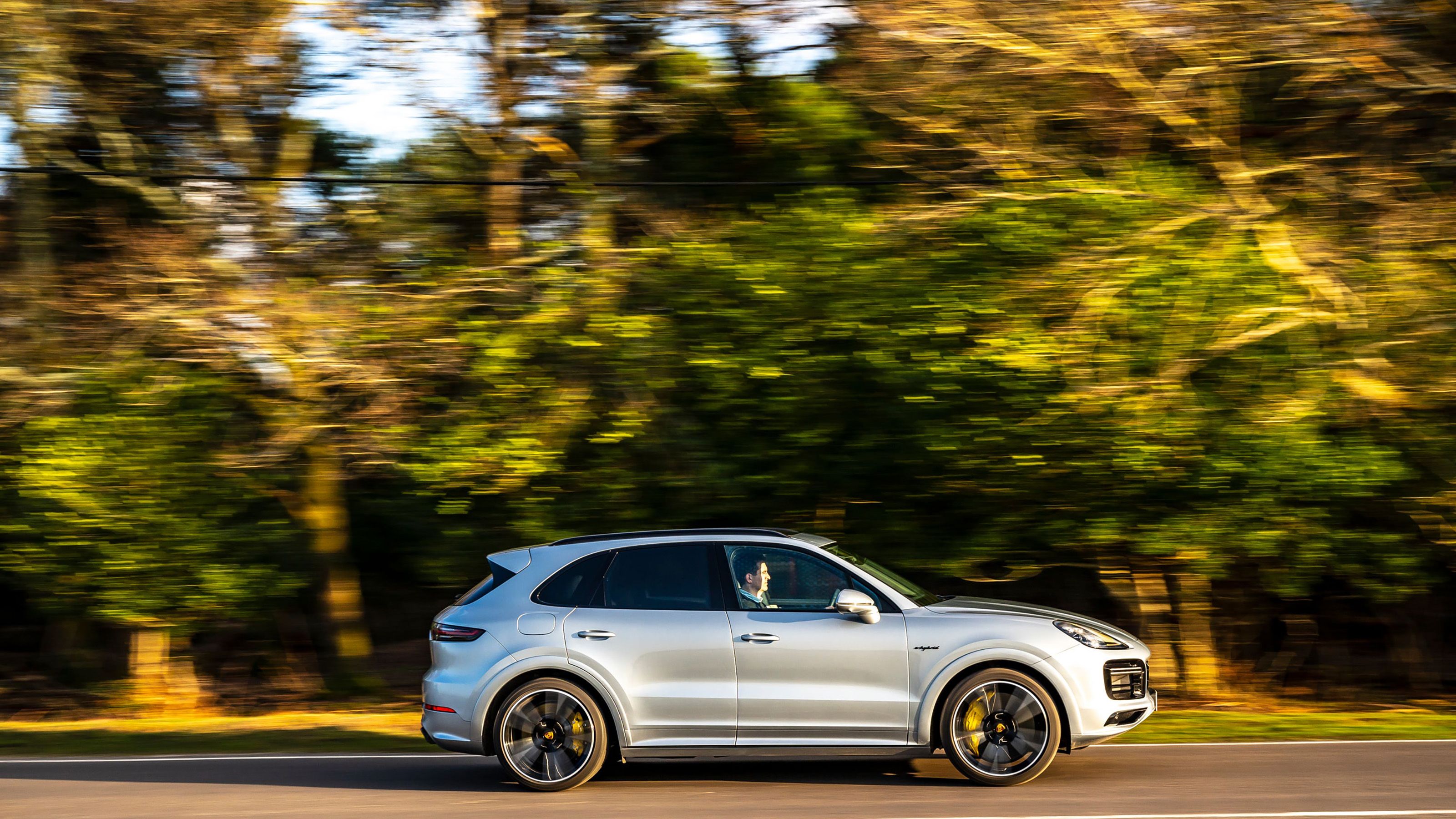 Silver Porsche Cayenne side driving