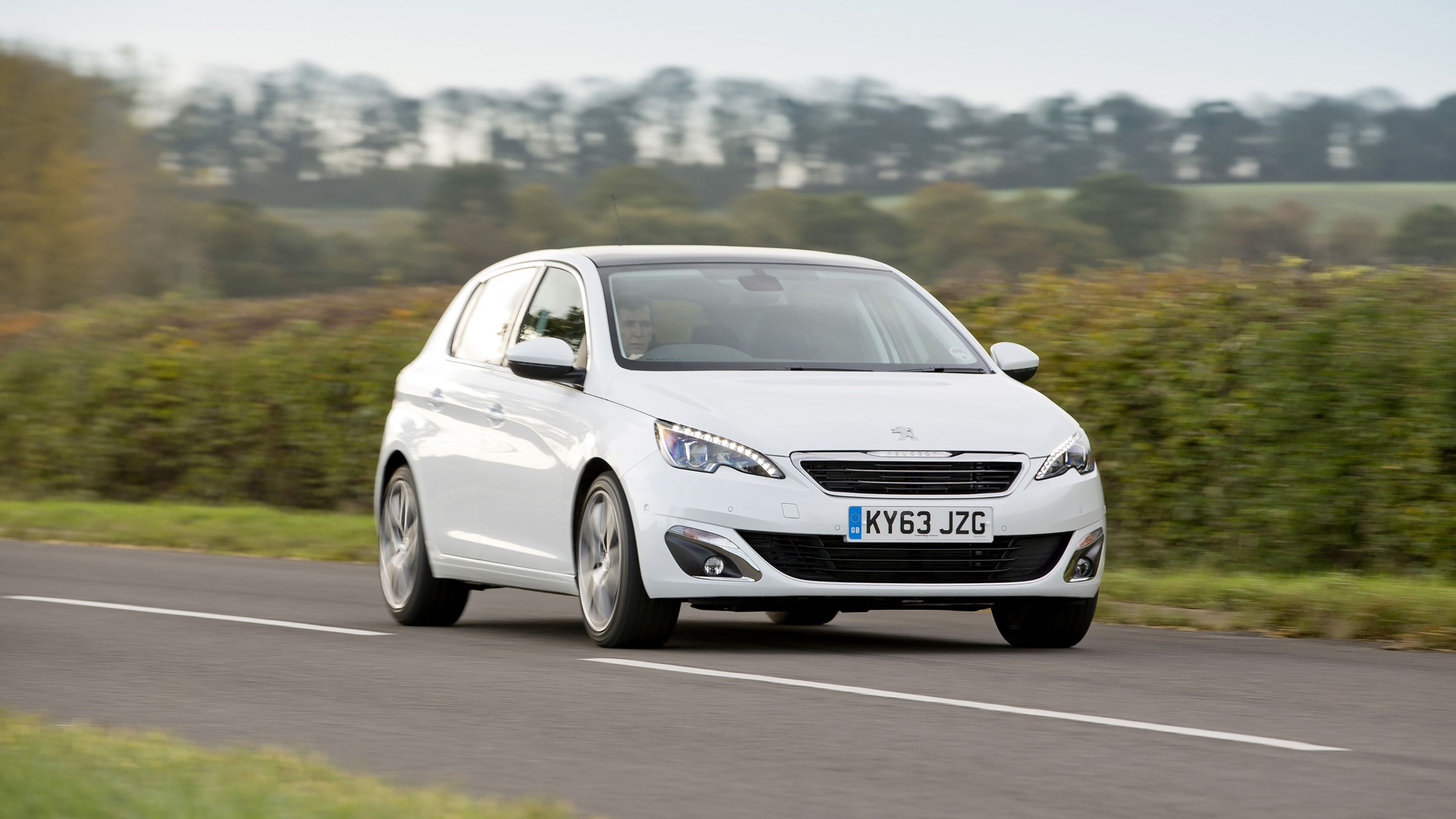 White Peugeot 308 driving