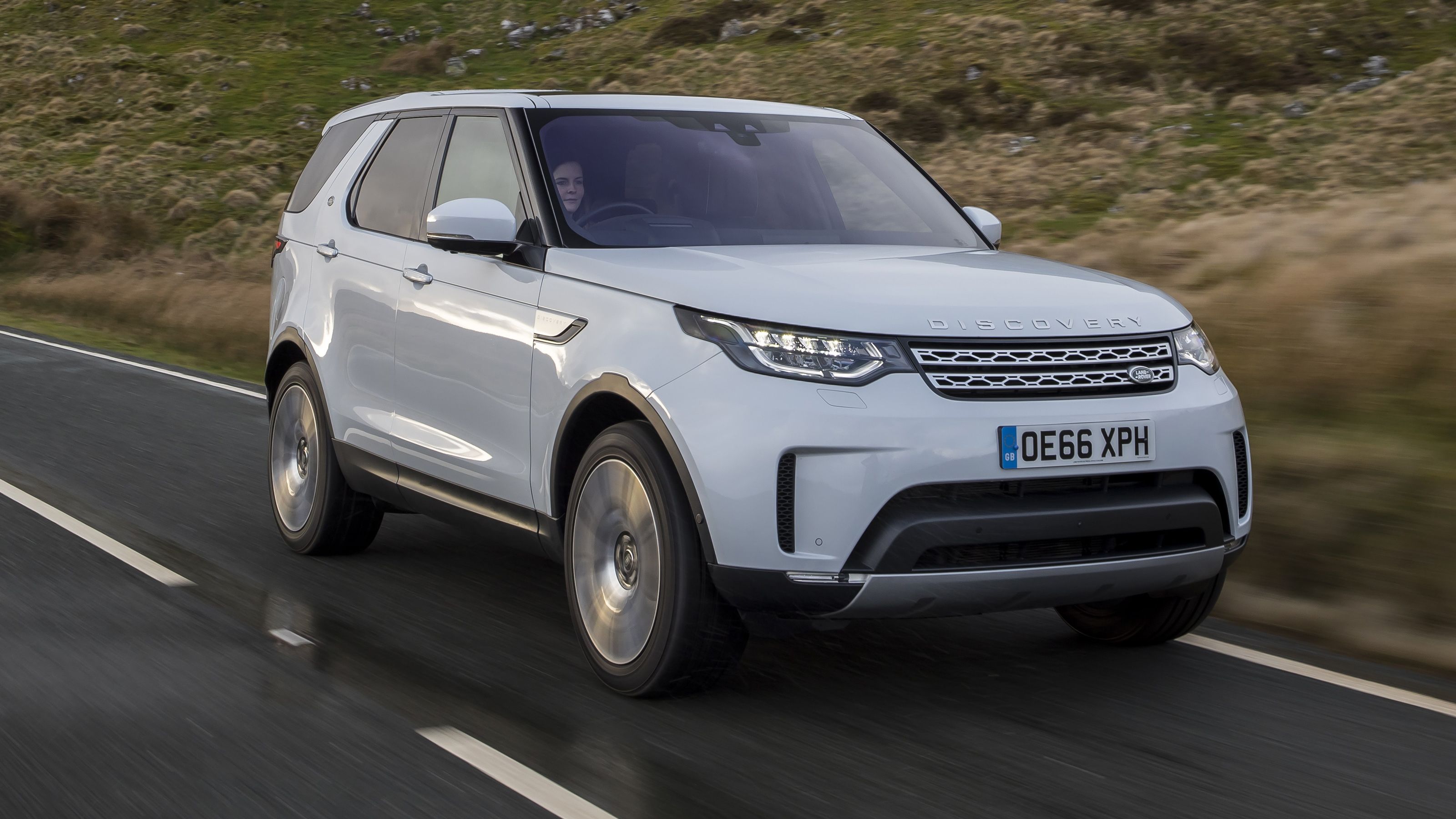 White Land Rover Discovery front driving