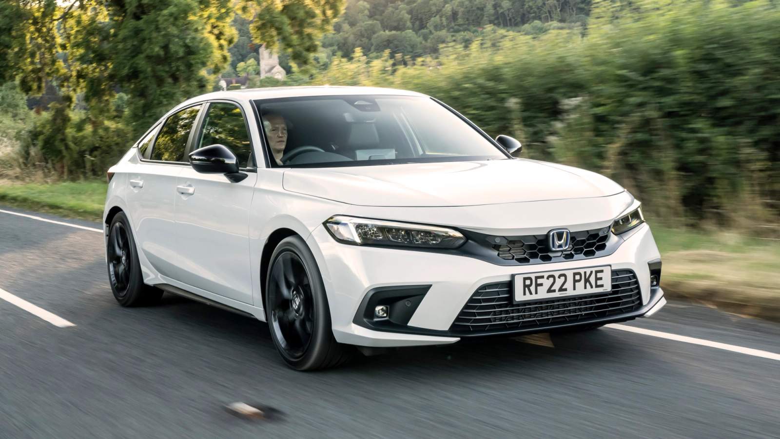 White Honda Civic Hybrid driving along a country lane