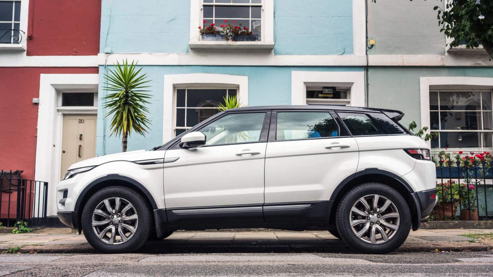 Range Rover Evoque parked outside a blue house