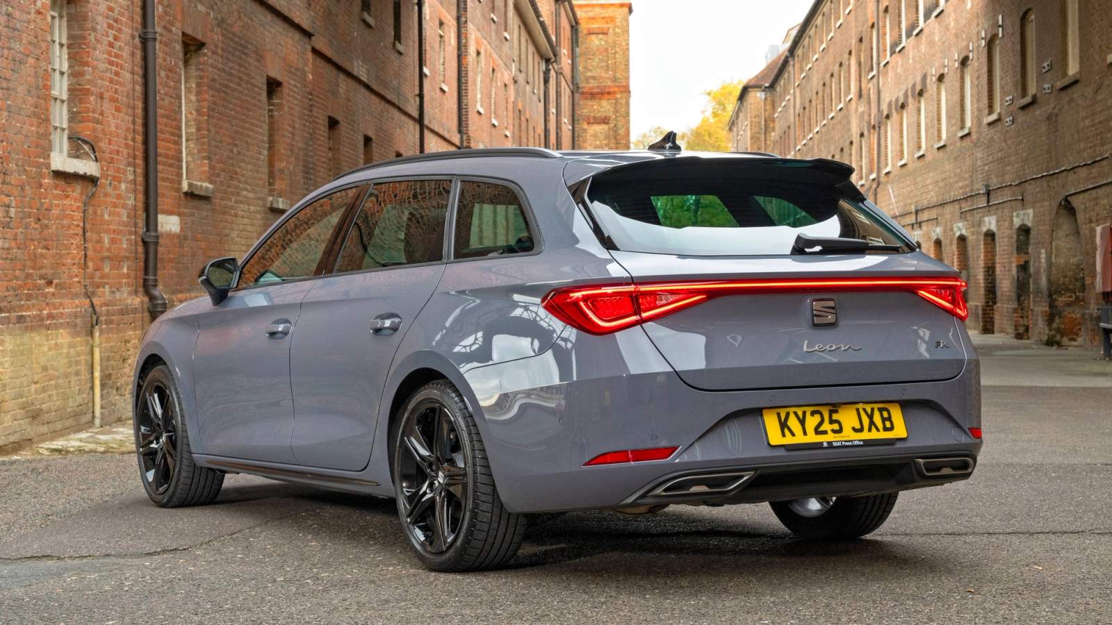 Grey SEAT Leon Estate parked by a factory 