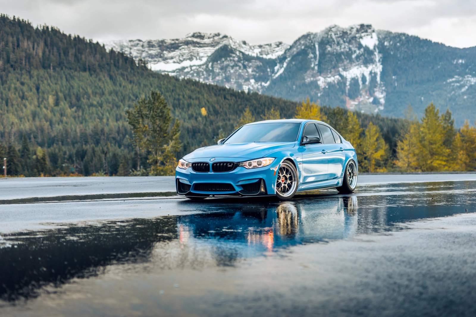 Blue car parked with mountains in the background