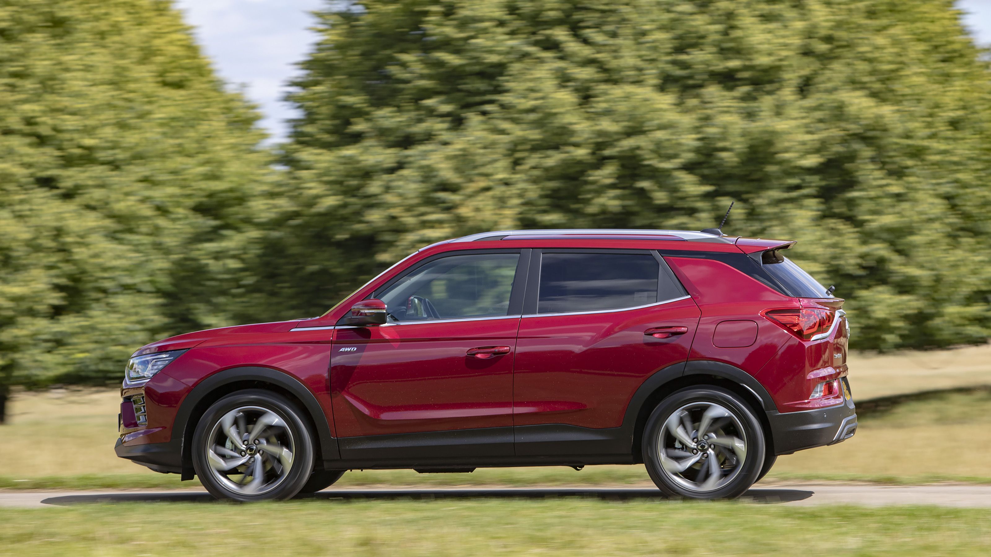 Red SsangYong Korando side driving
