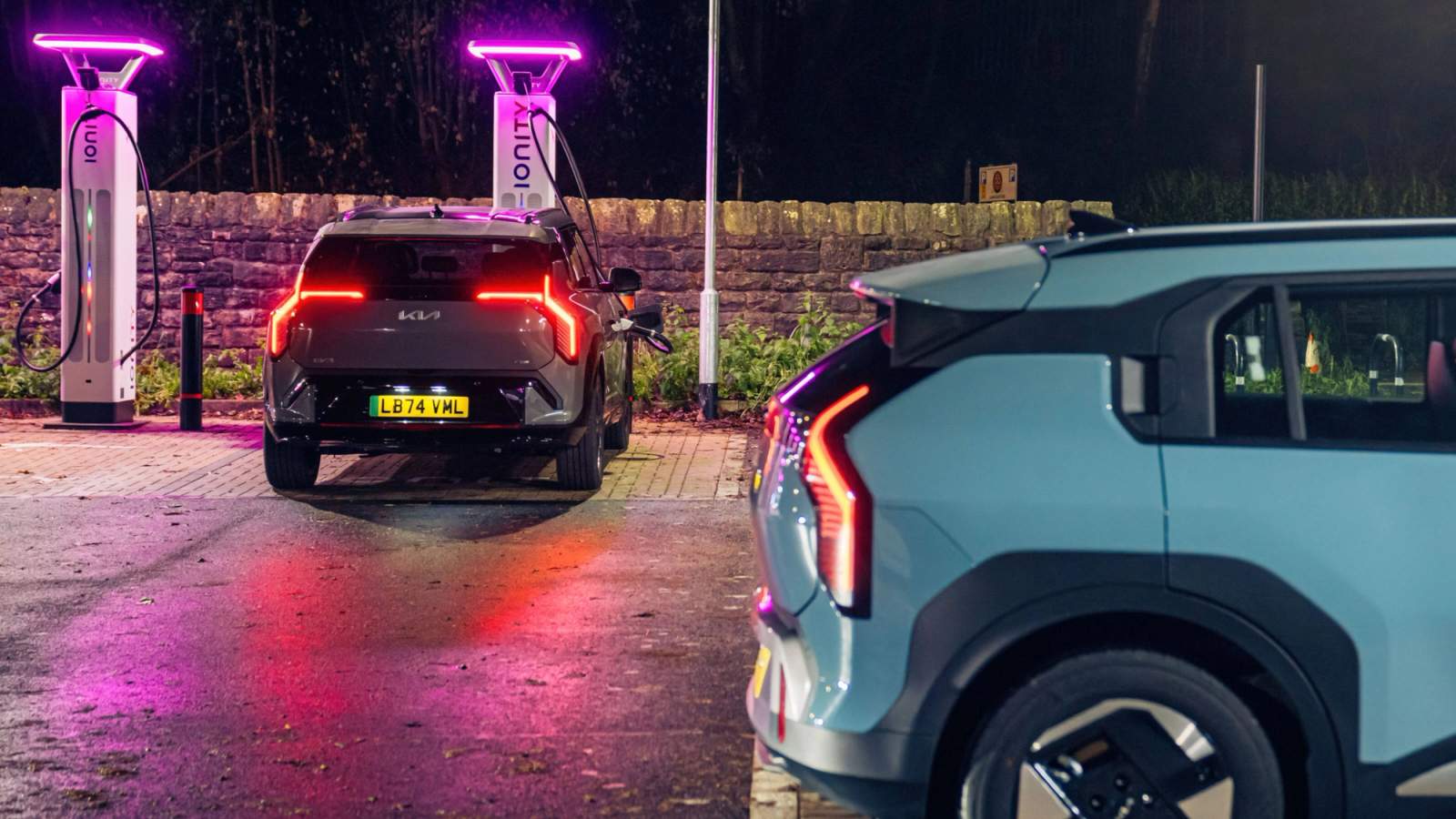 A blue and grey Kia EV3 rapid charging at an Ionity charging station at night