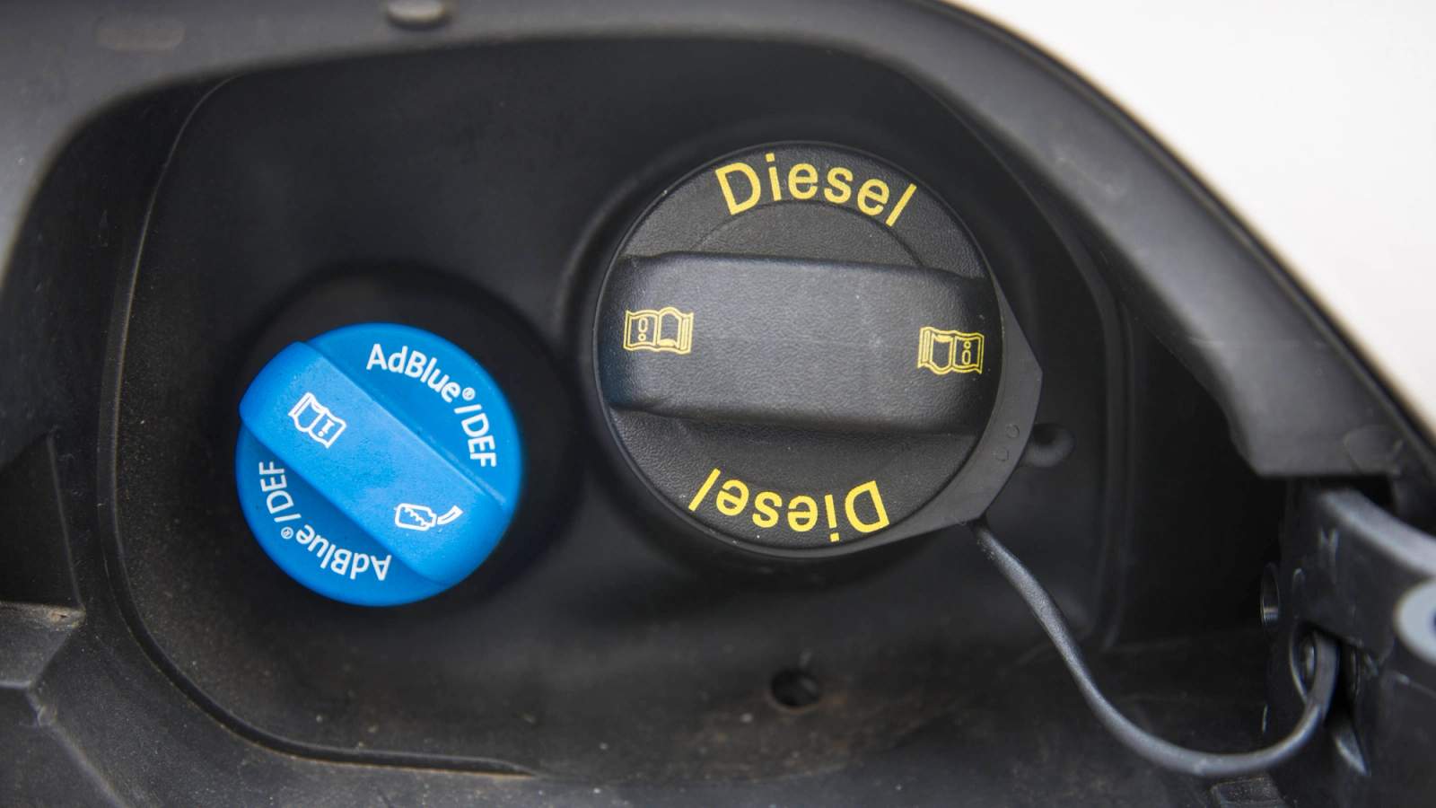adblue filler cap next to a diesel filler cap