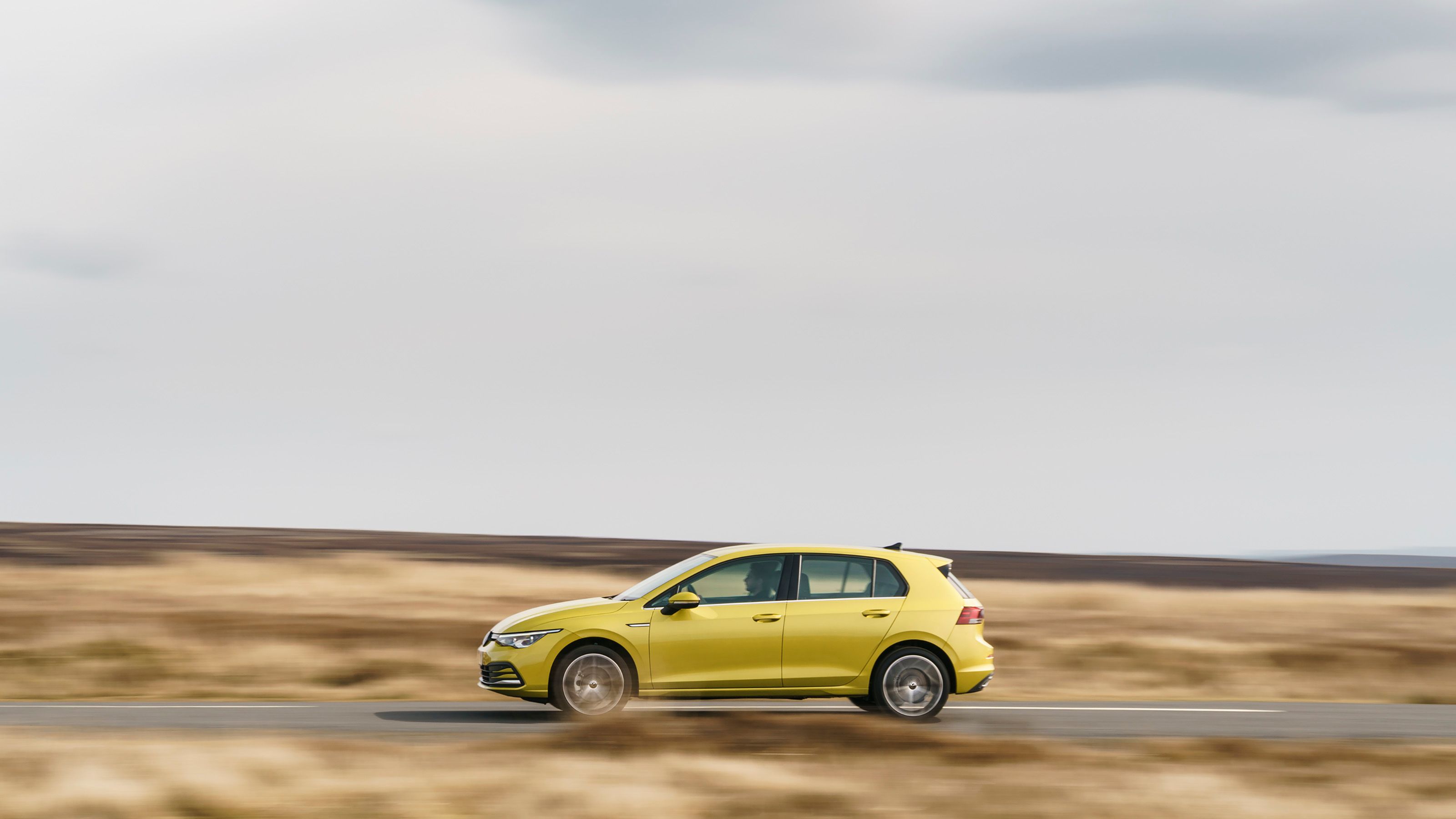 Green Volkswagen Golf side driving