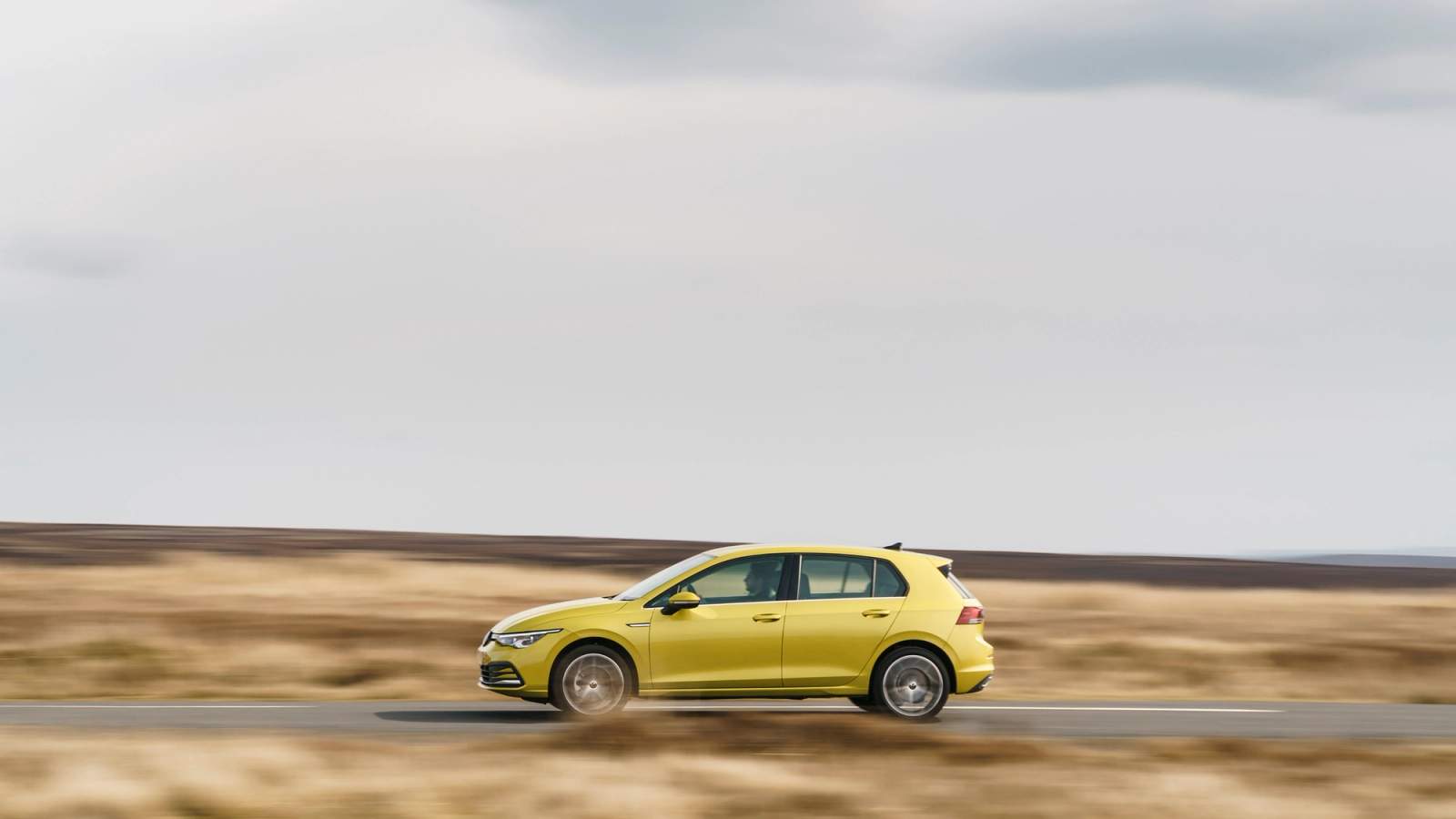 Green Volkswagen Golf side driving