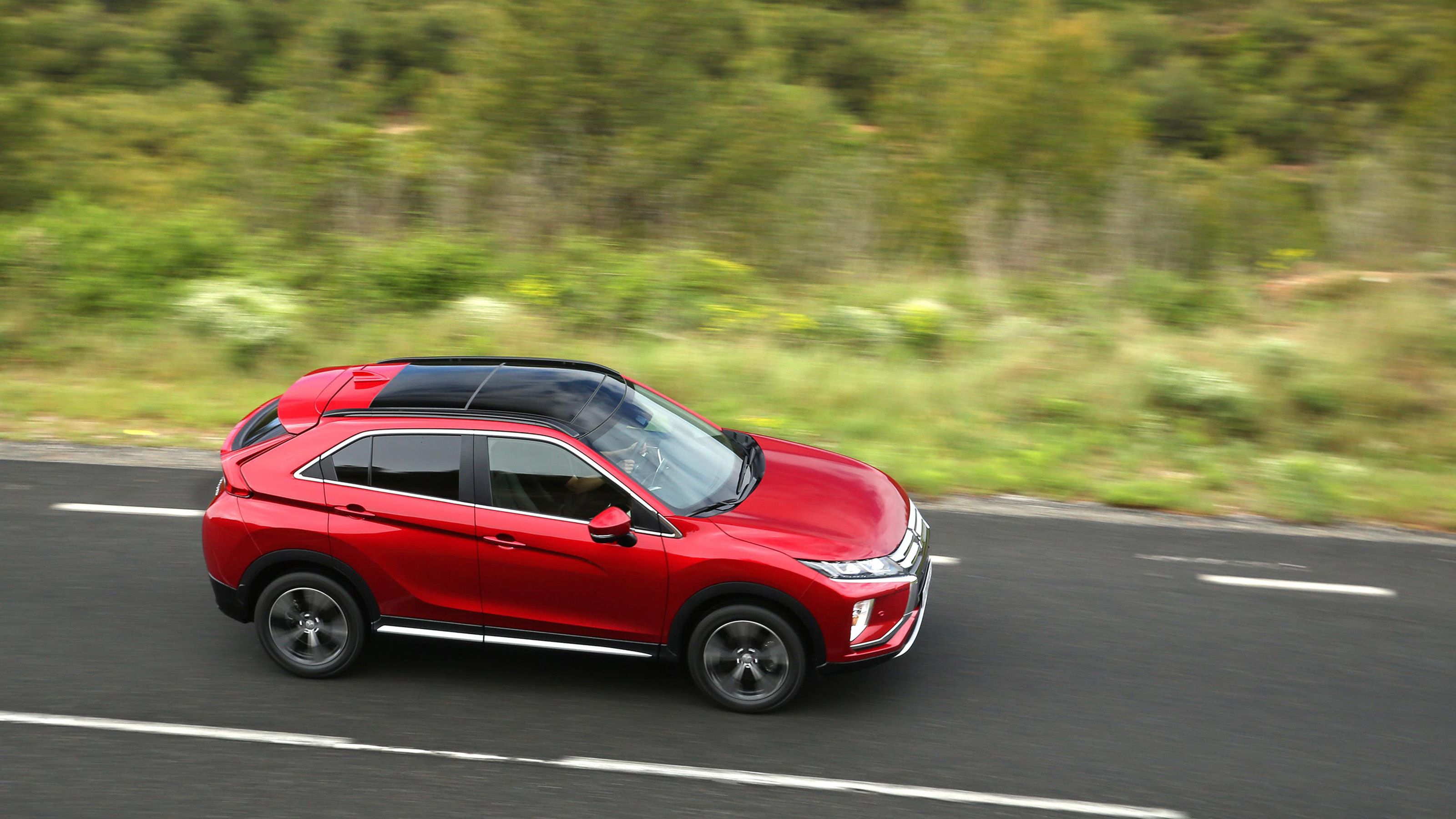 Red Mitsubishi Eclipse Cross side driving
