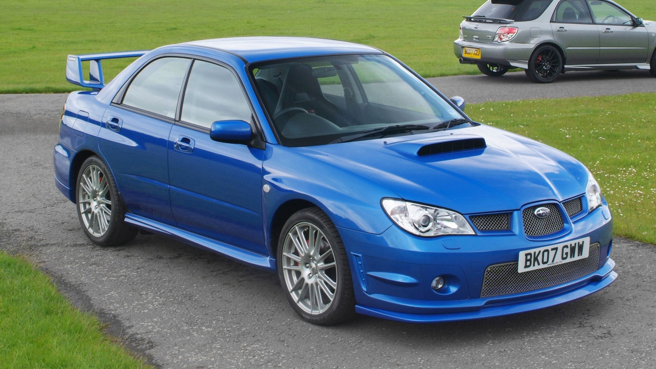 Blue Subaru Impreza parked on grass