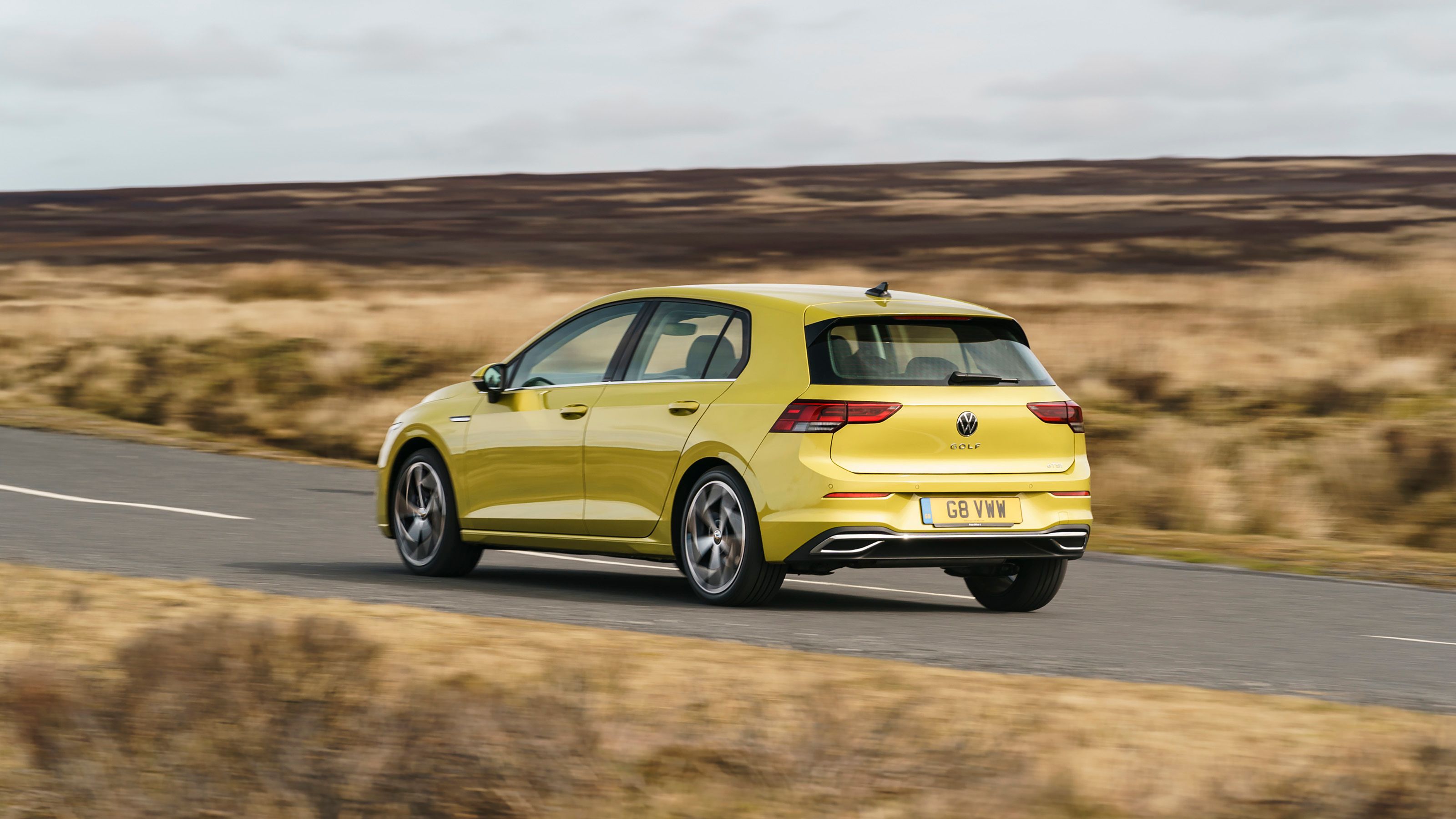 Green Volkswagen Golf rear driving