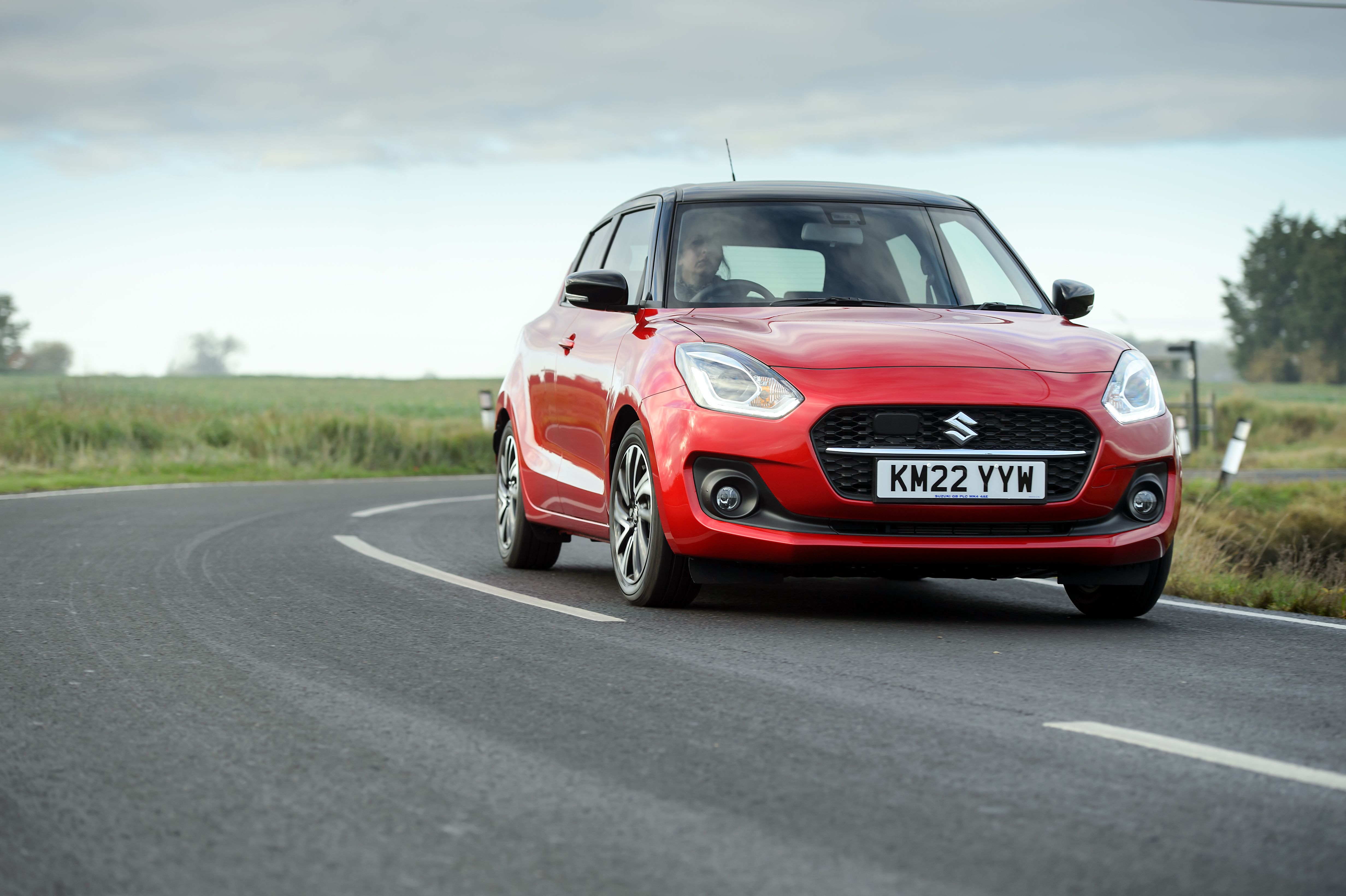 Red Suzuki Swift driving