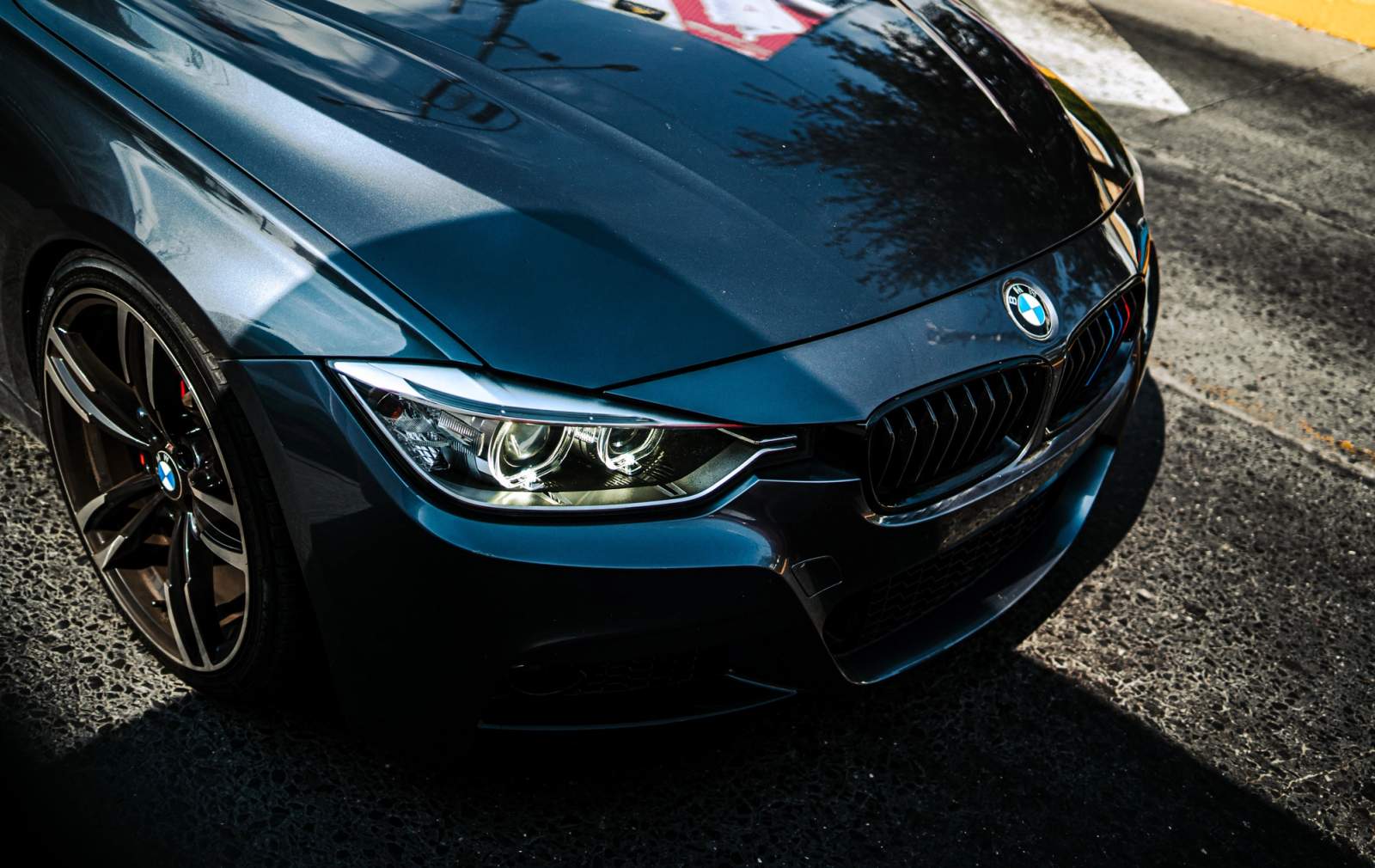 front of BMW blue car