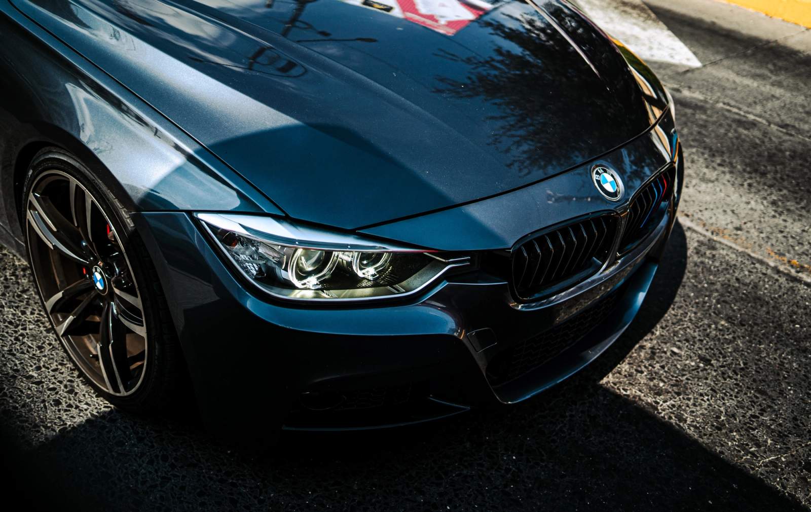 front of BMW blue car