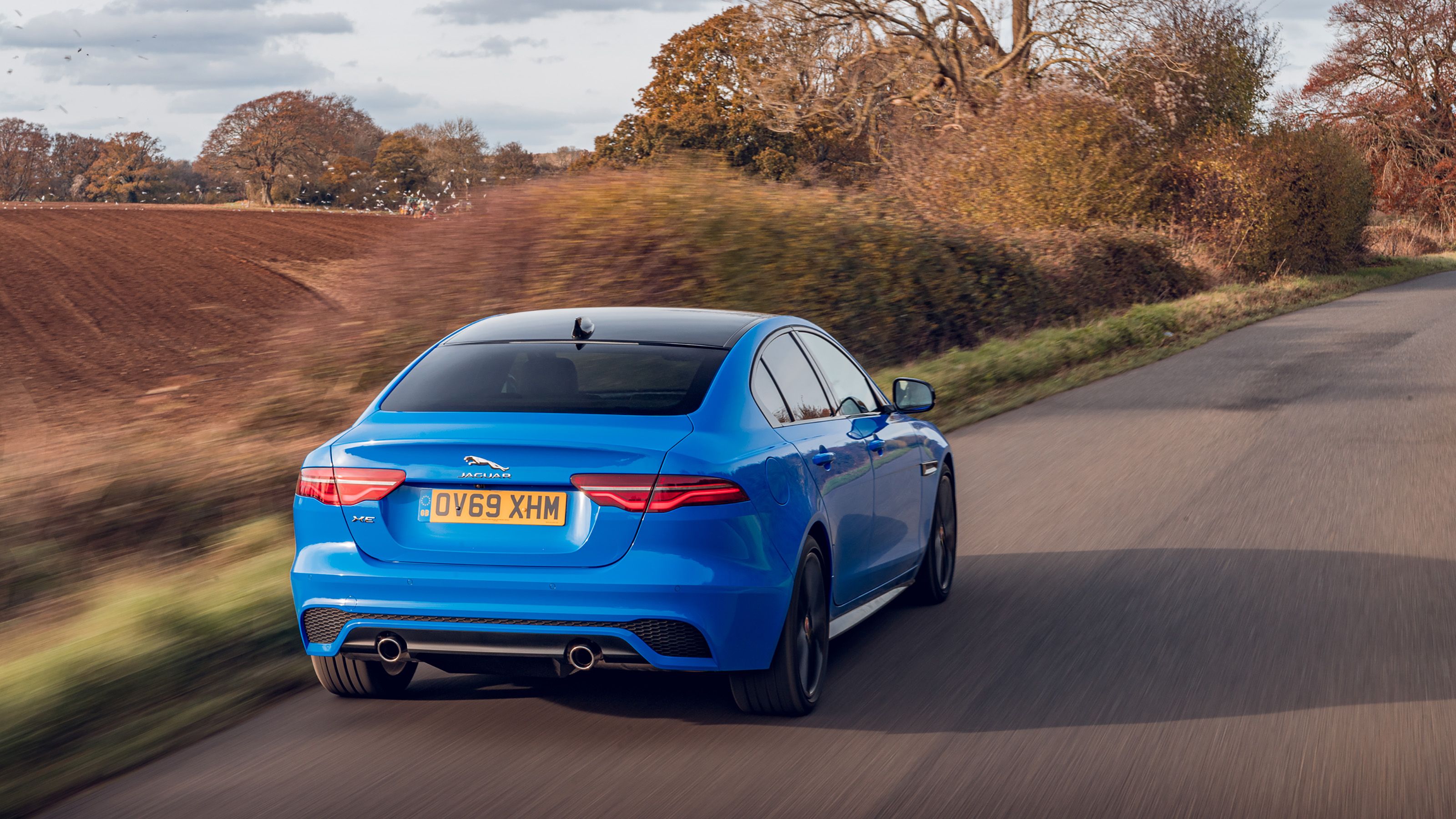 Blue Jaguar XE rear driving