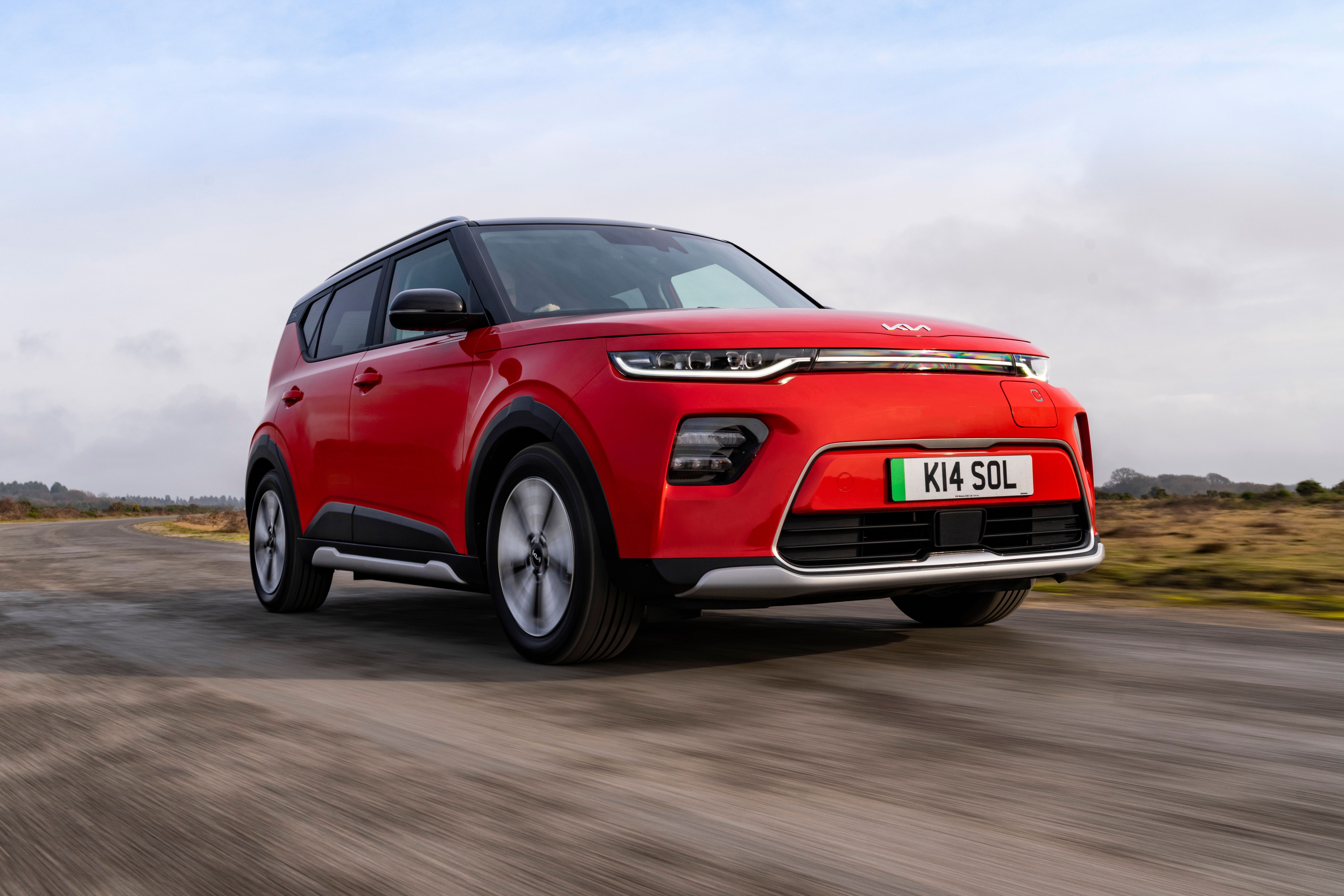 Red Kia Soul EV driving