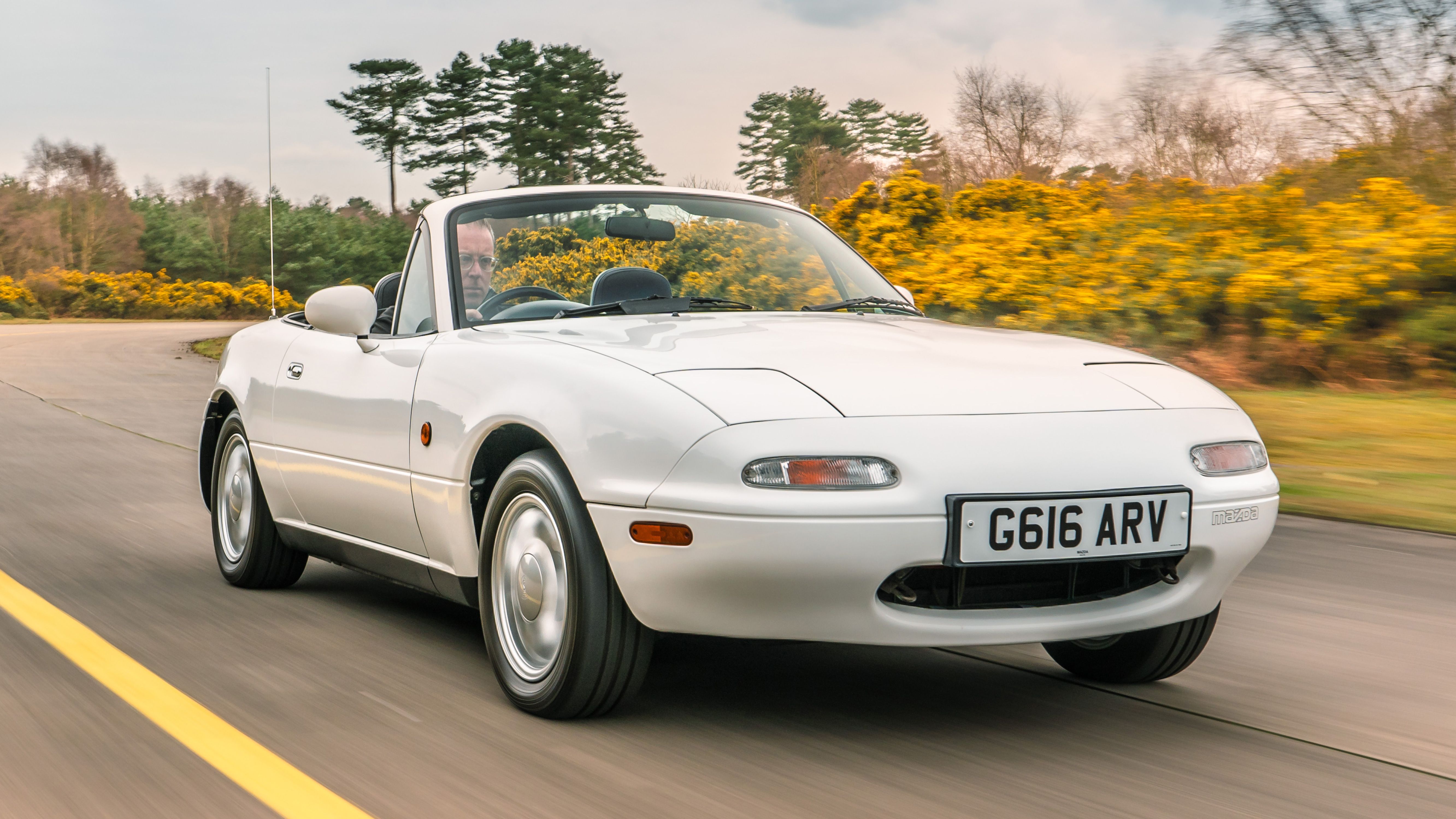 White Mazda MX-5 driving on a road
