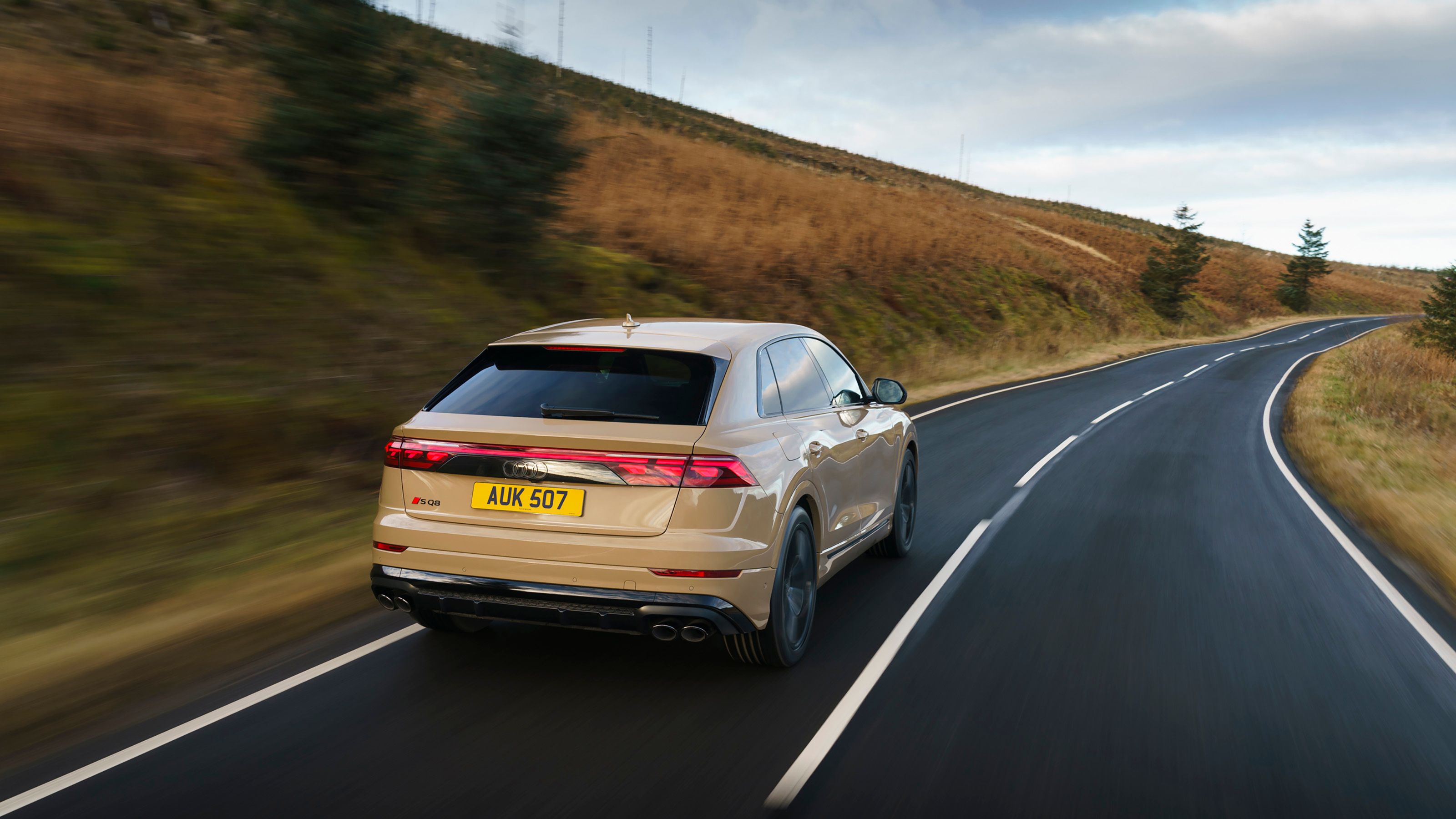 Beige Audi SQ8 rear driving