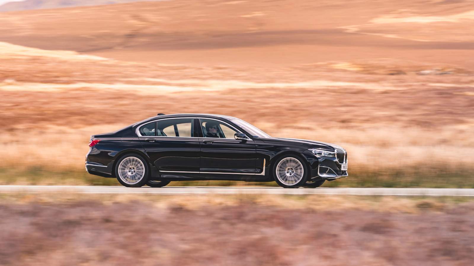Black BMW 7 Series side driving