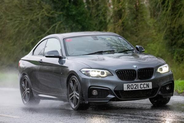 Black car on the road on rainy day
