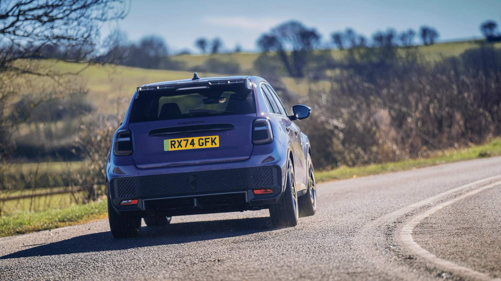 Abarth 600e driving round a corner