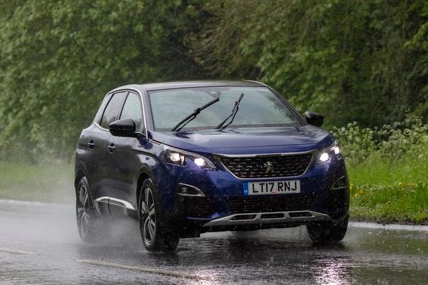 blue car on the road in the rain