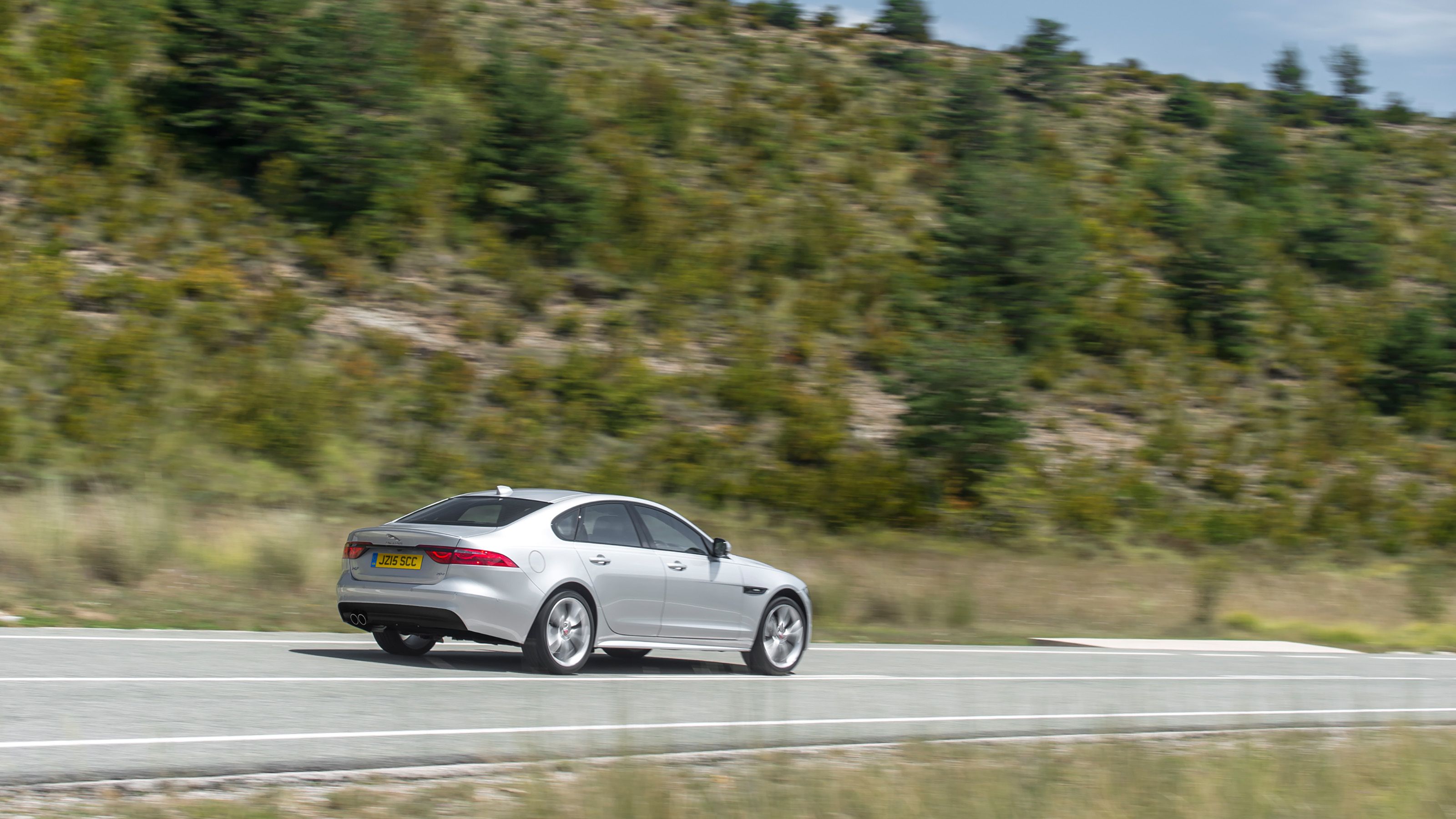 Silver Jaguar XF side driving