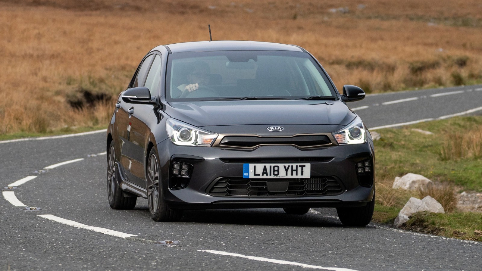 Grey Kia Rio front driving