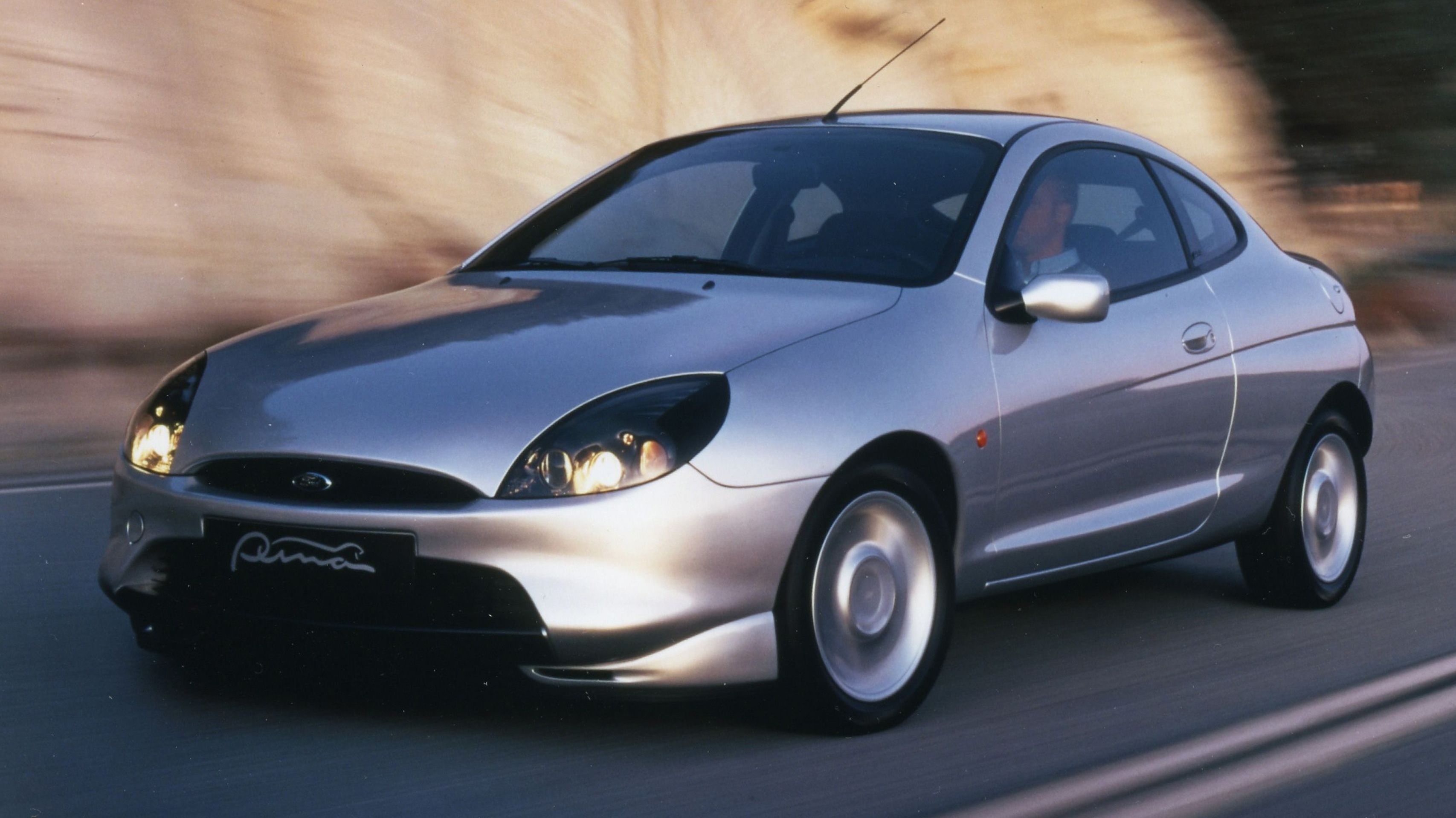 Silver Ford Puma driving on road