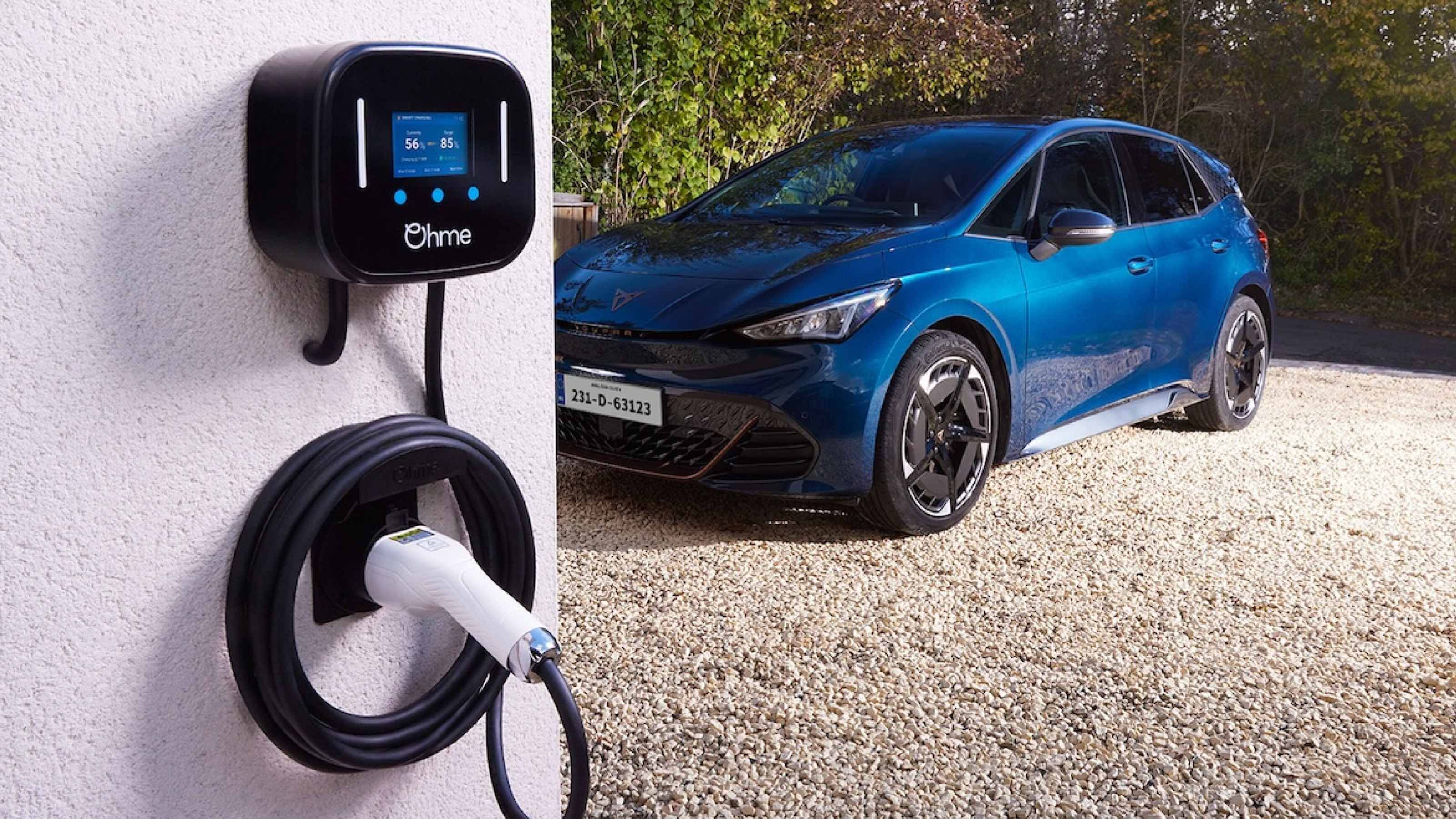 Blue Cupra Born parked on a driveway near an Ohme wallbox charger