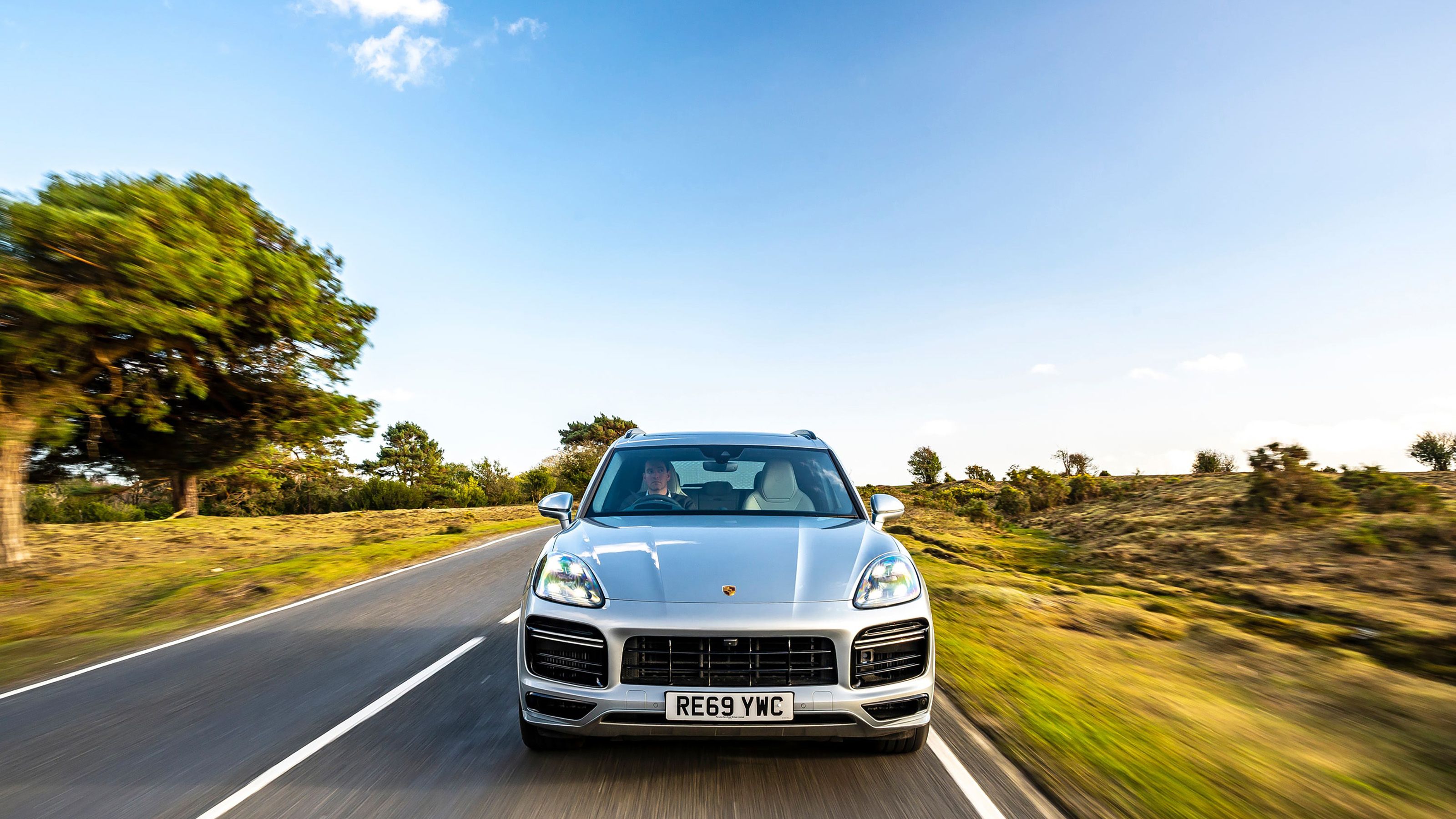 Silver Porsche Cayenne front driving